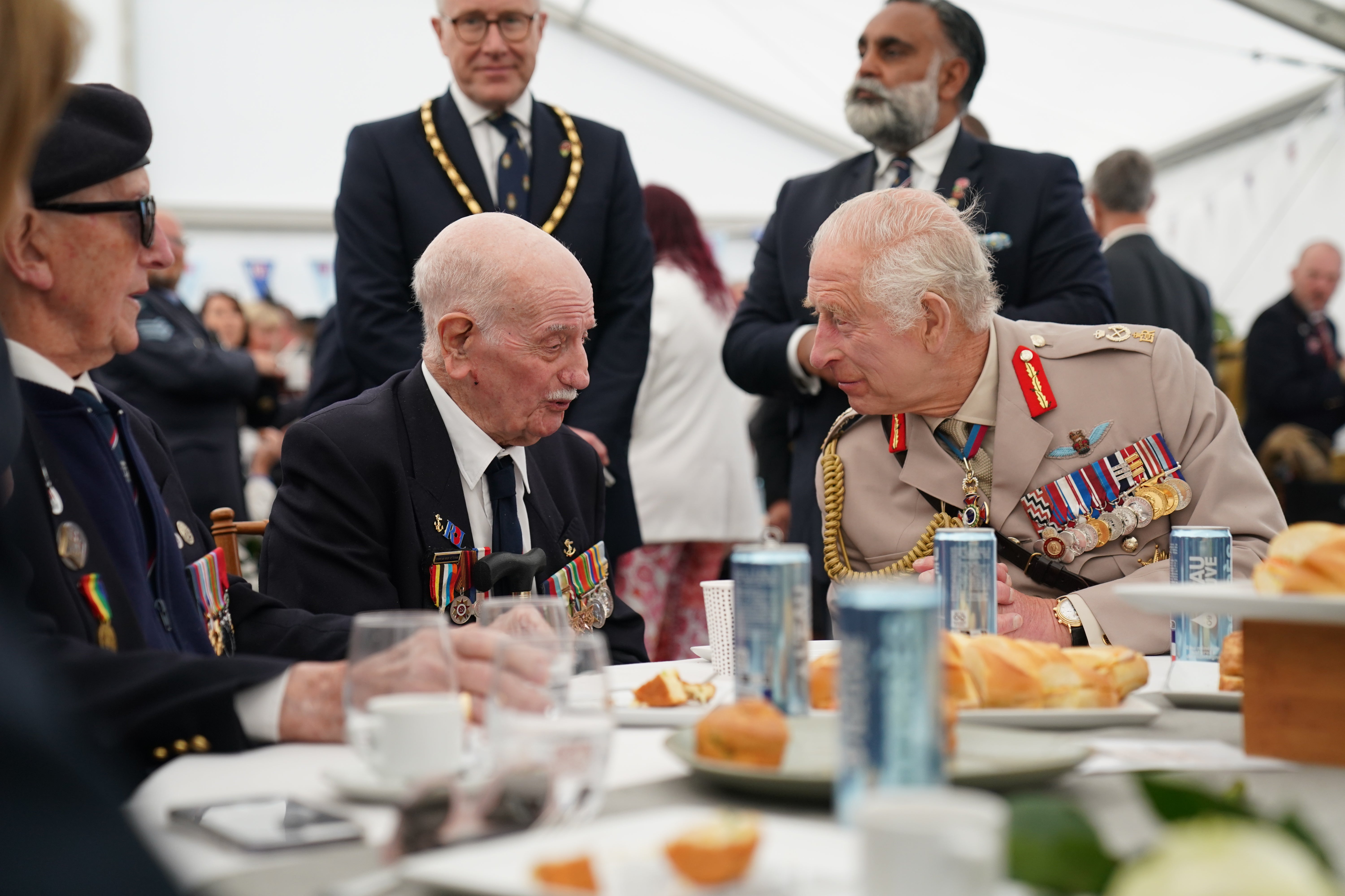 King Charles III speaks with D-Day veteran Arnie Salter, 98, from Warwickshire