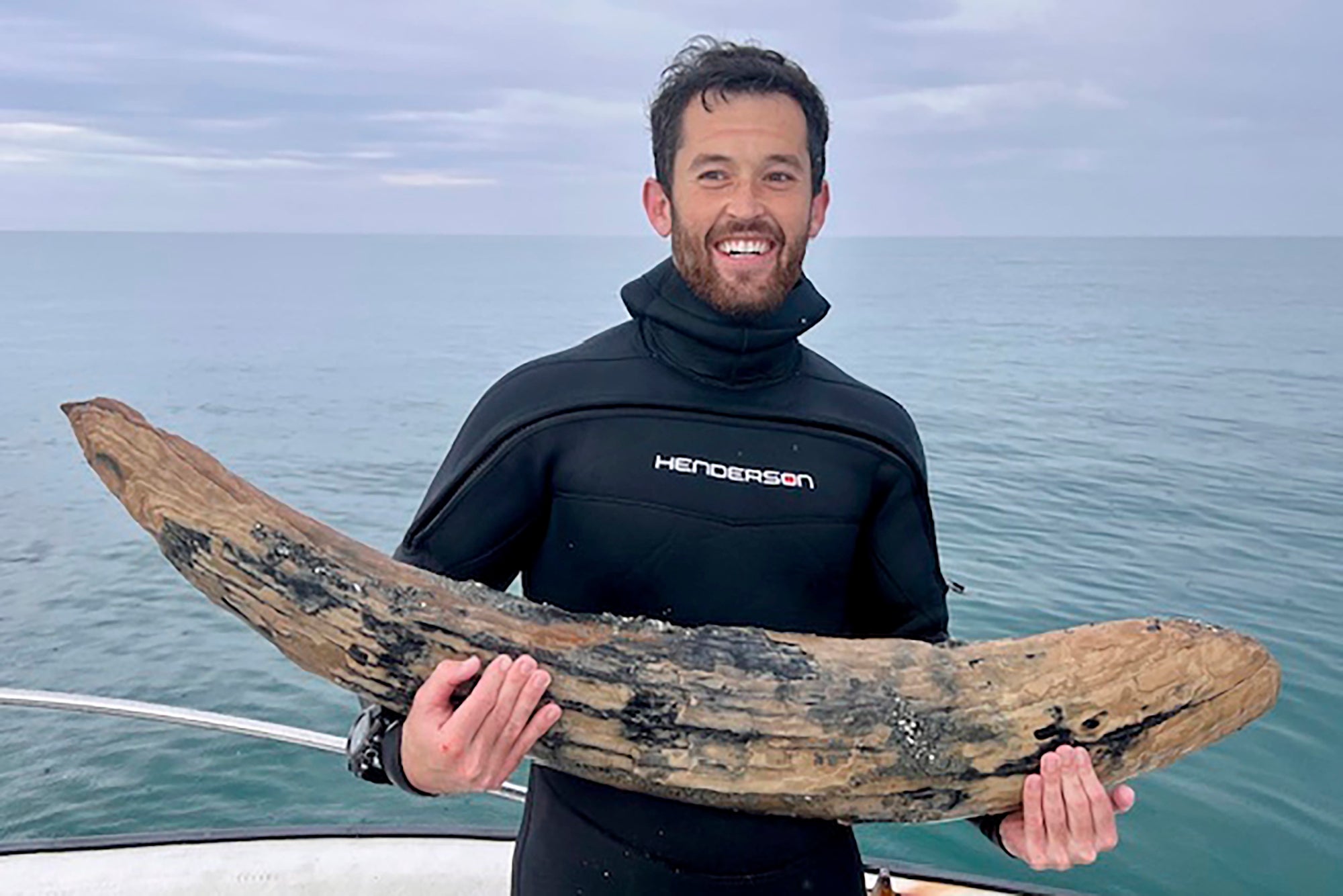 This April 2024 photo taken by Blair Morrow and provided by Alex Lundberg shows Lundberg holding a large section of tusk from a long-extinct mastodon that he and his diver companion found on the sea floor off Florida’s Gulf coast