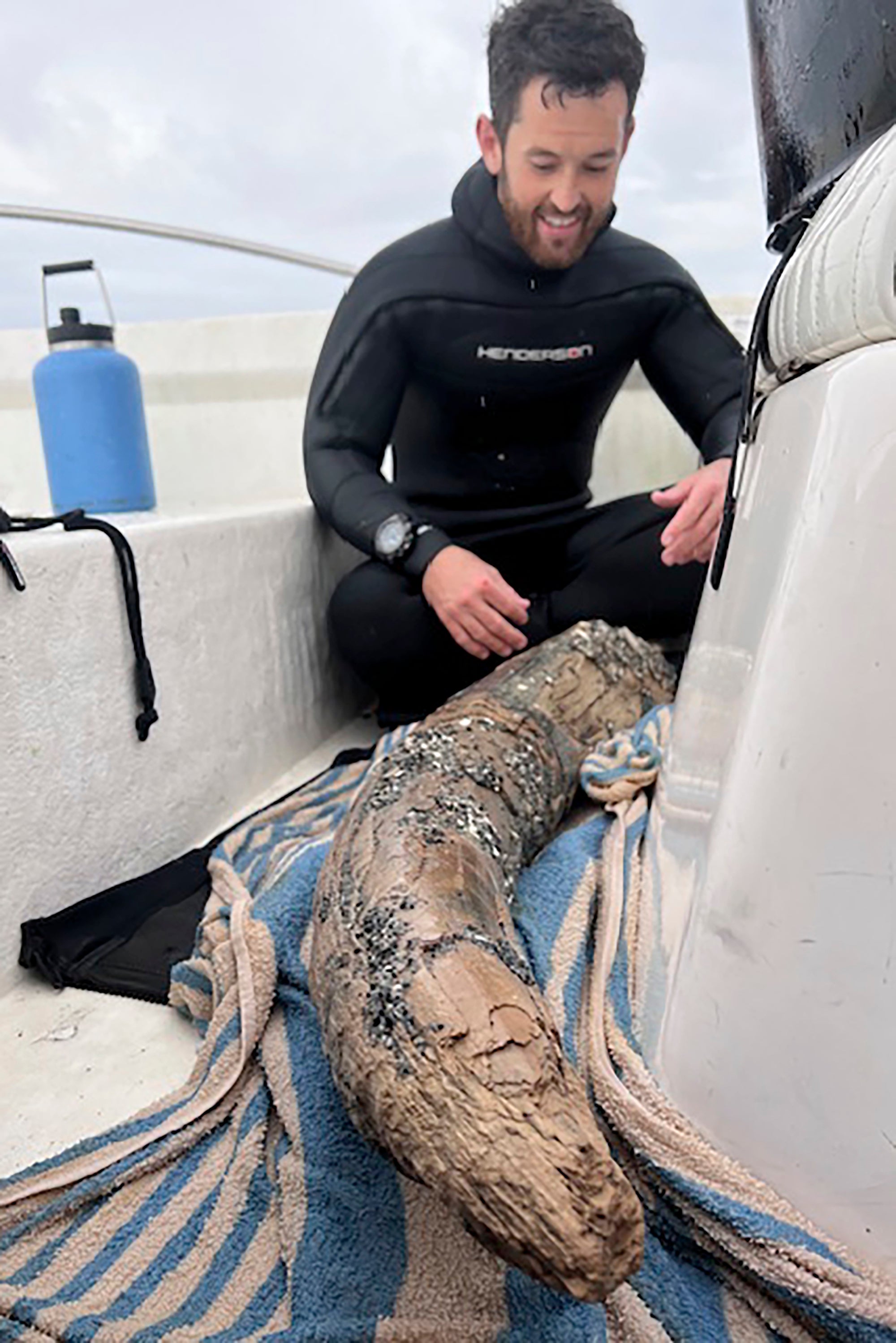 This April 2024 photo taken by Blair Morrow and provided by Alex Lundberg shows Lundberg with a large section of tusk from a long-extinct mastodon that he and his diver companion found on the sea floor off Florida's Gulf coast