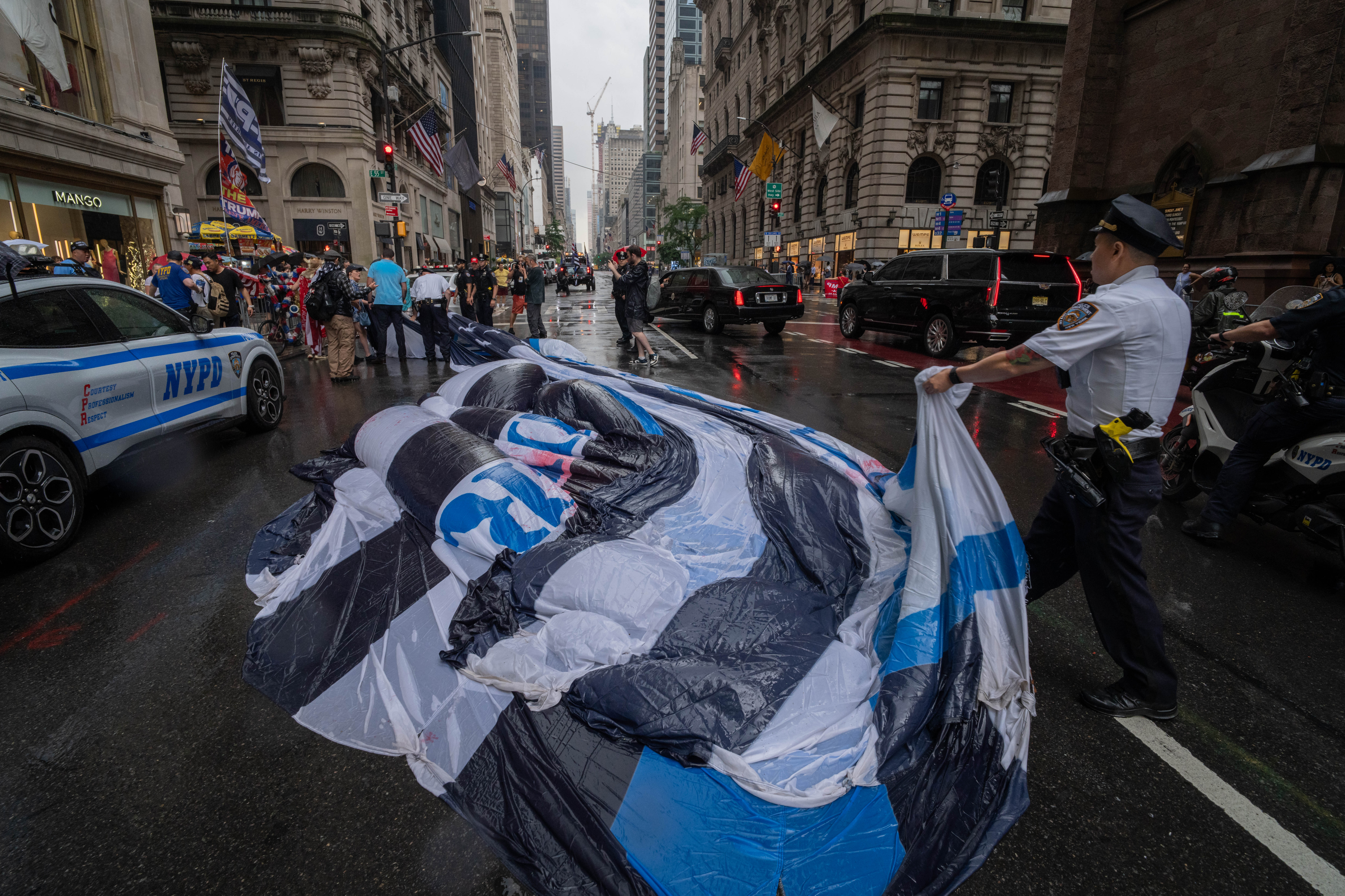 NYPD officers remove a giant Trump flag from the street as they detain those who carried it during a 'Thin Blue Trump Parade' on June 6, 2024 in New York City