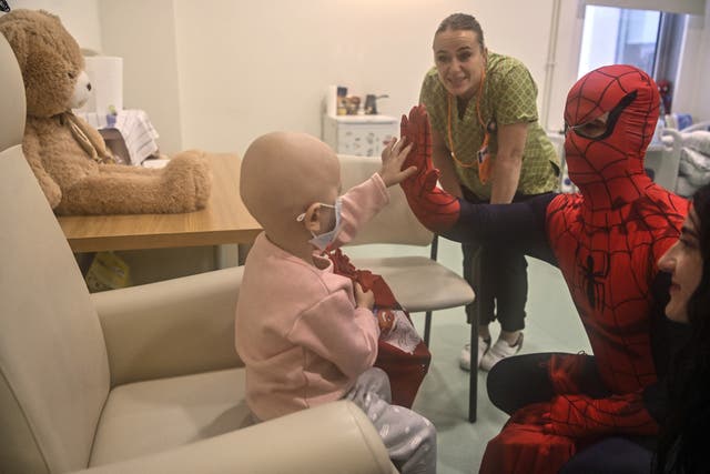 <p>A man dressed as Spiderman entertains a child fighting cancer at a hospital in Pristina, Kosovo</p>