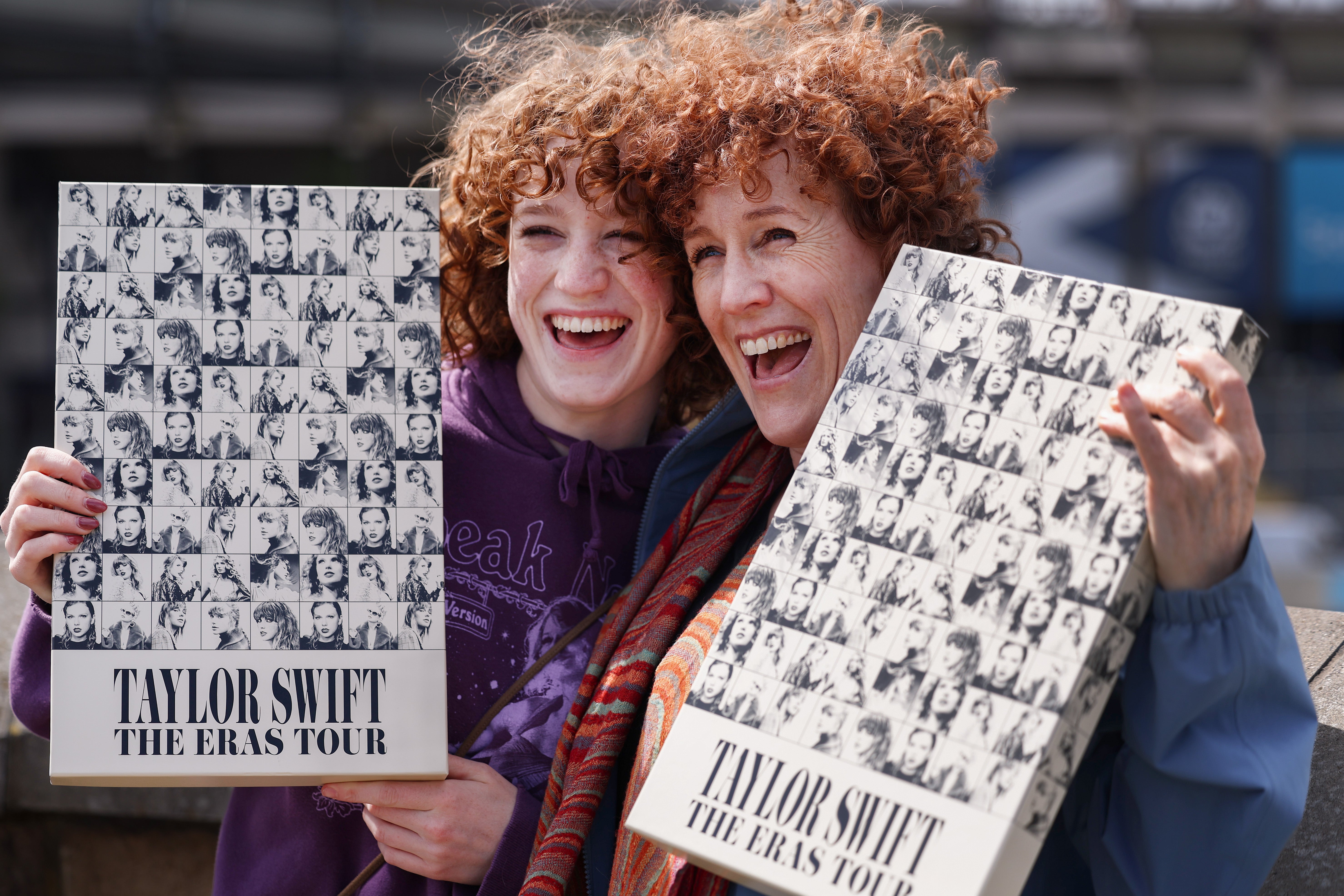Taylor Swift fans pose with merch as they queue outside Murrayfield Stadium in Edinburgh, Scotland, the day before the pop star headlines the first of her UK Eras shows