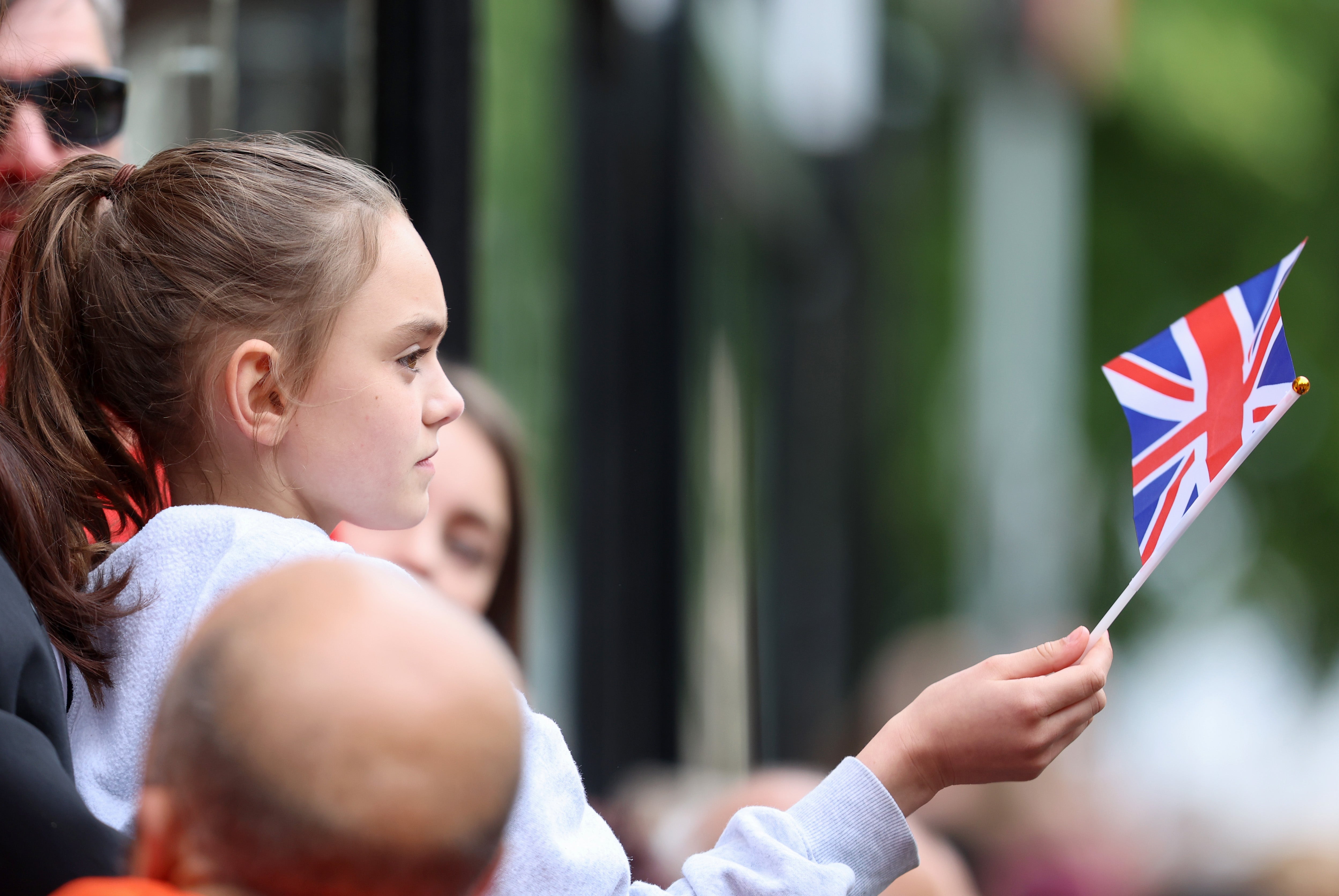 A girl waves a Union Jack flag as she stands outside the cathedral