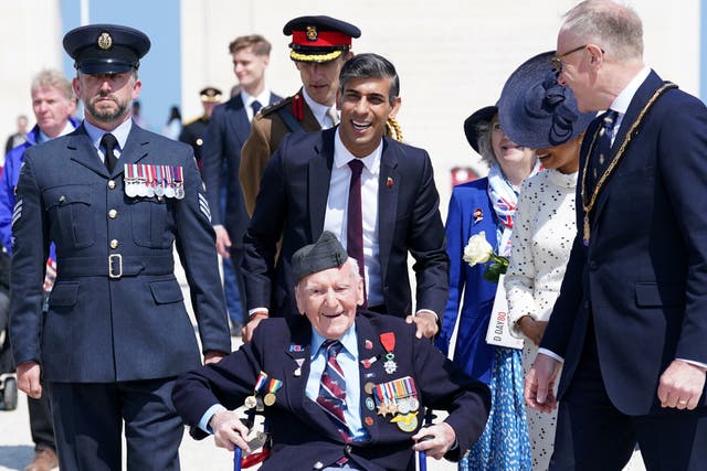<p>Rishi Sunak smiles as he pushes Bernard Morgan, 100, in his wheelchair  </p>