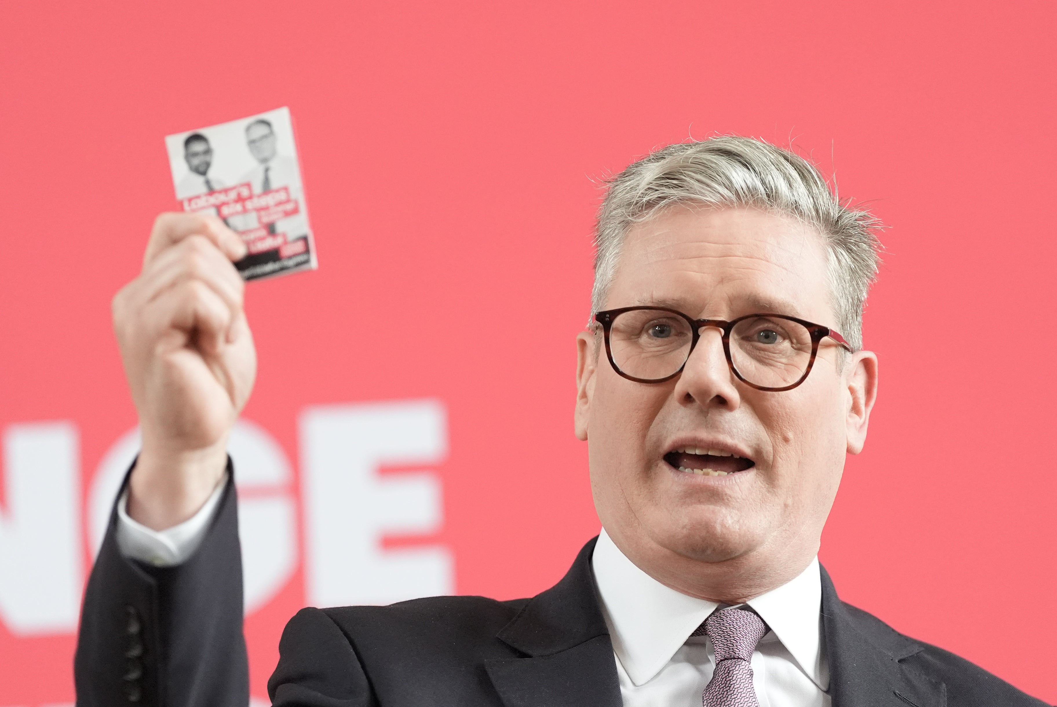Keir Starmer holding a card bearing Labour’s pledges
