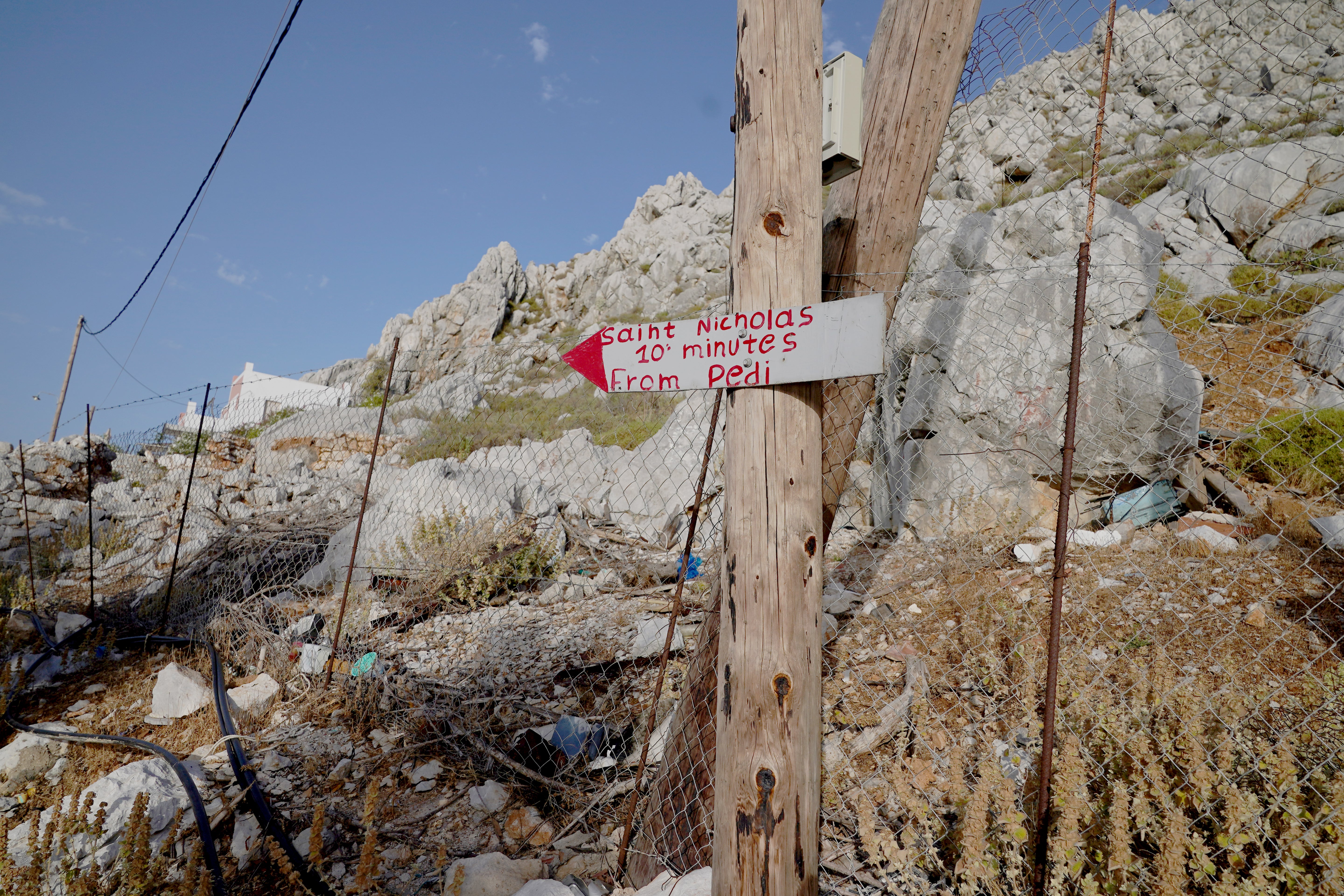 A sign points to Saint Nikolas Beach in the Pedi area of Symi, Greece, where a search and rescue operation is under way for TV doctor and columnist Michael Mosley after he went missing while on holiday.