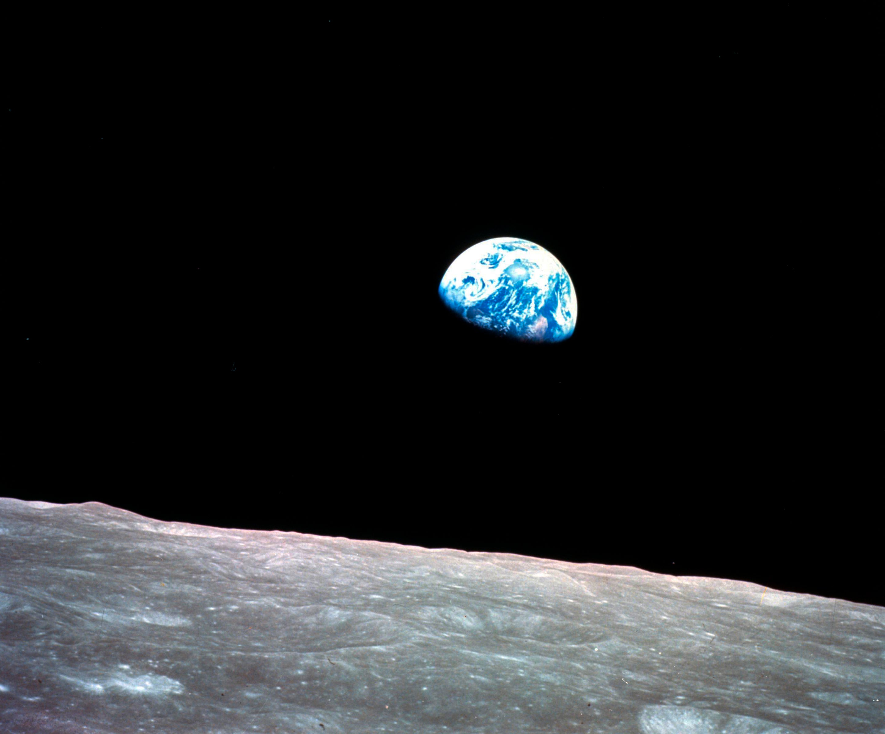 1968, file photo made available by NASA shows the Earth behind the surface of the moon during the Apollo 8 mission