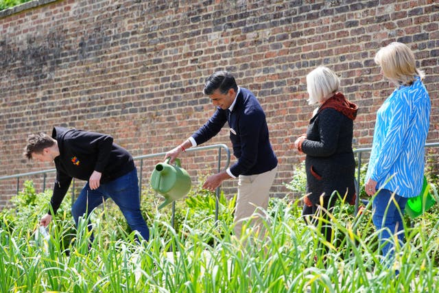 Prime Minister Rishi Sunak using a watering can during a visit to Big Help Out project in Bishop Auckland, County Durham (Peter Byrne/PA)