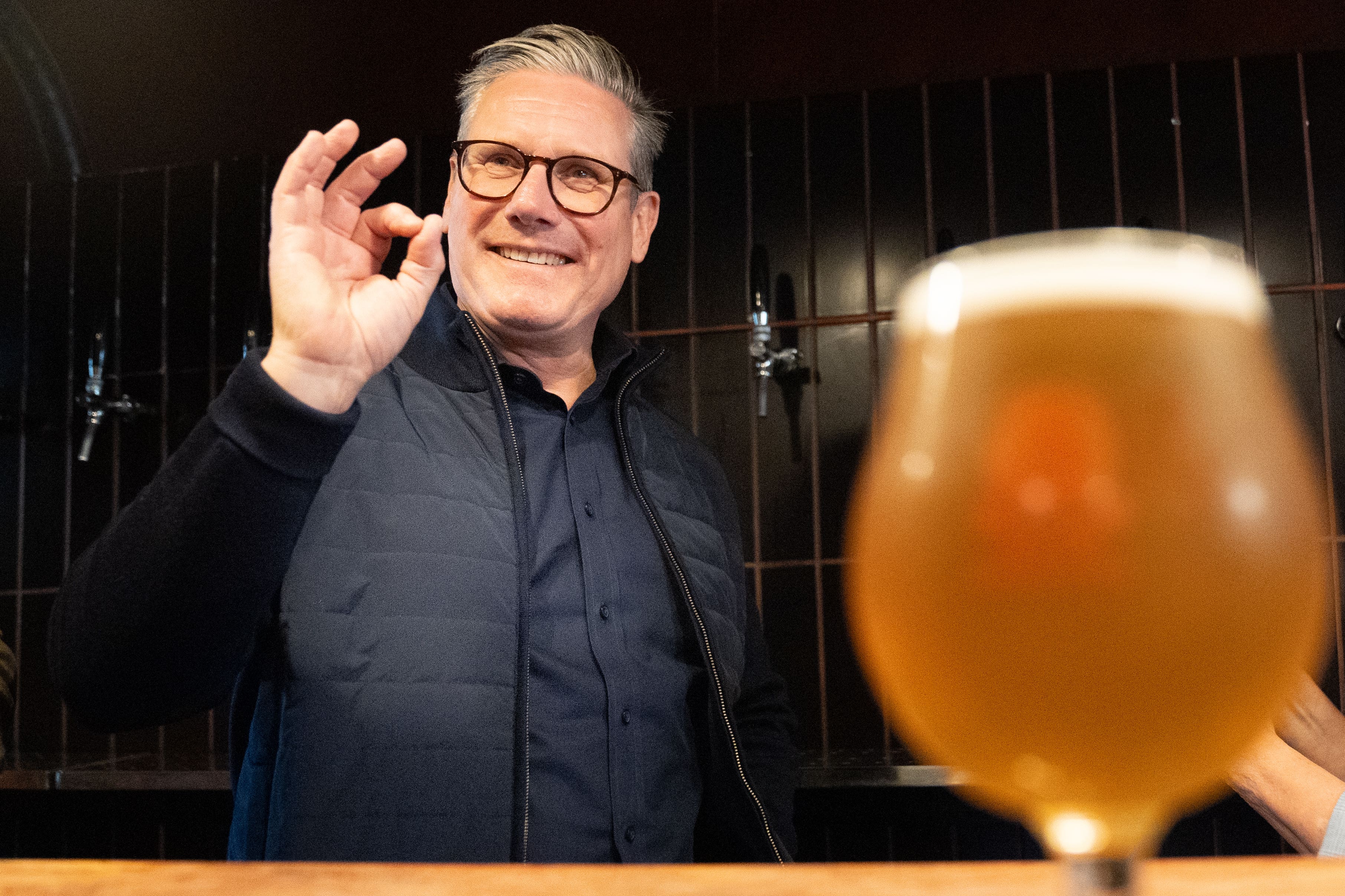 Labour leader Sir Keir Starmer helps to serve drinks during a campaign visit to a small business – 3 Lock’s Brewery in Camden (Stefan Rousseau/PA)