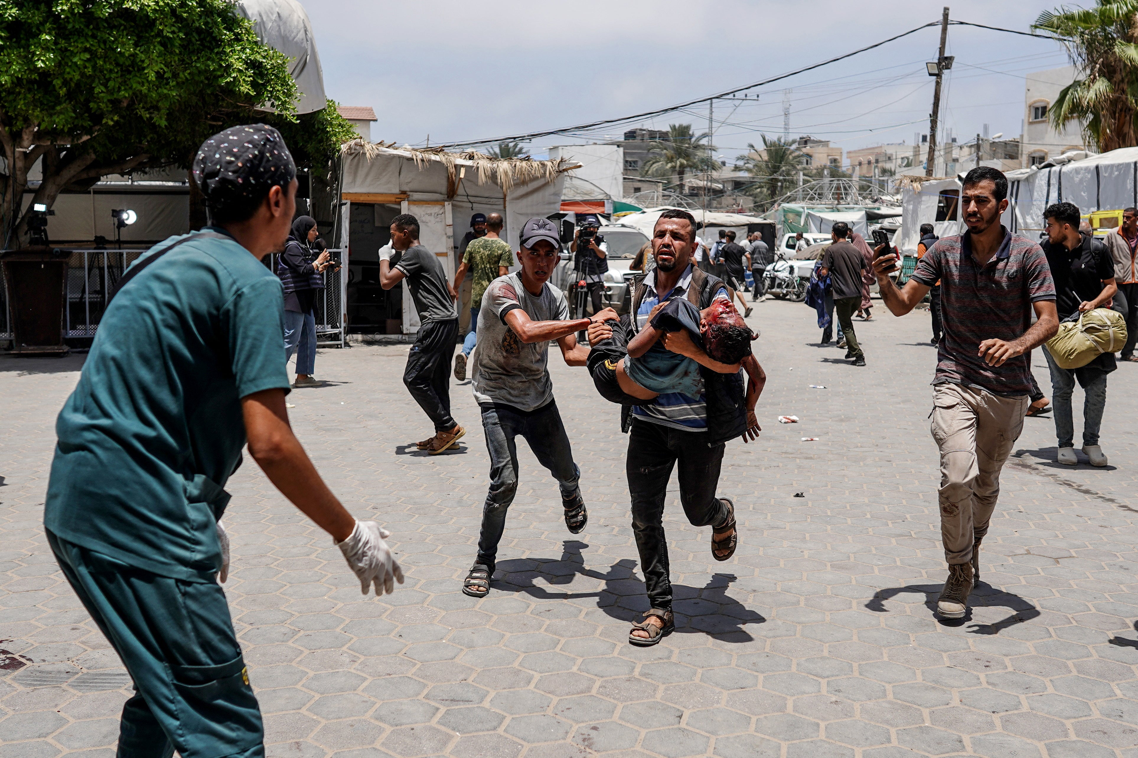 A man hurriedly dragged the injured child to the medics at Al-Aqsa Hospital