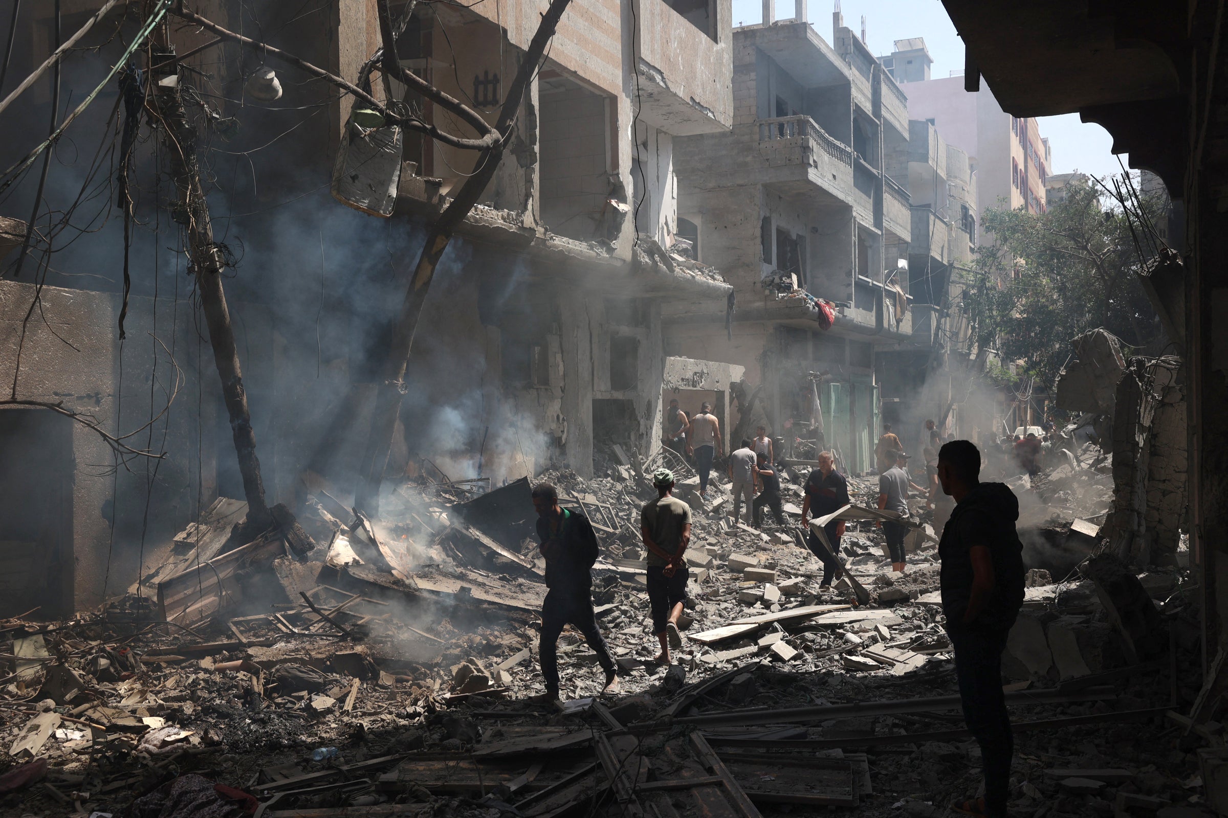 People walk across the rubble of destroyed buildings in the Nuseirat camp in Gaza