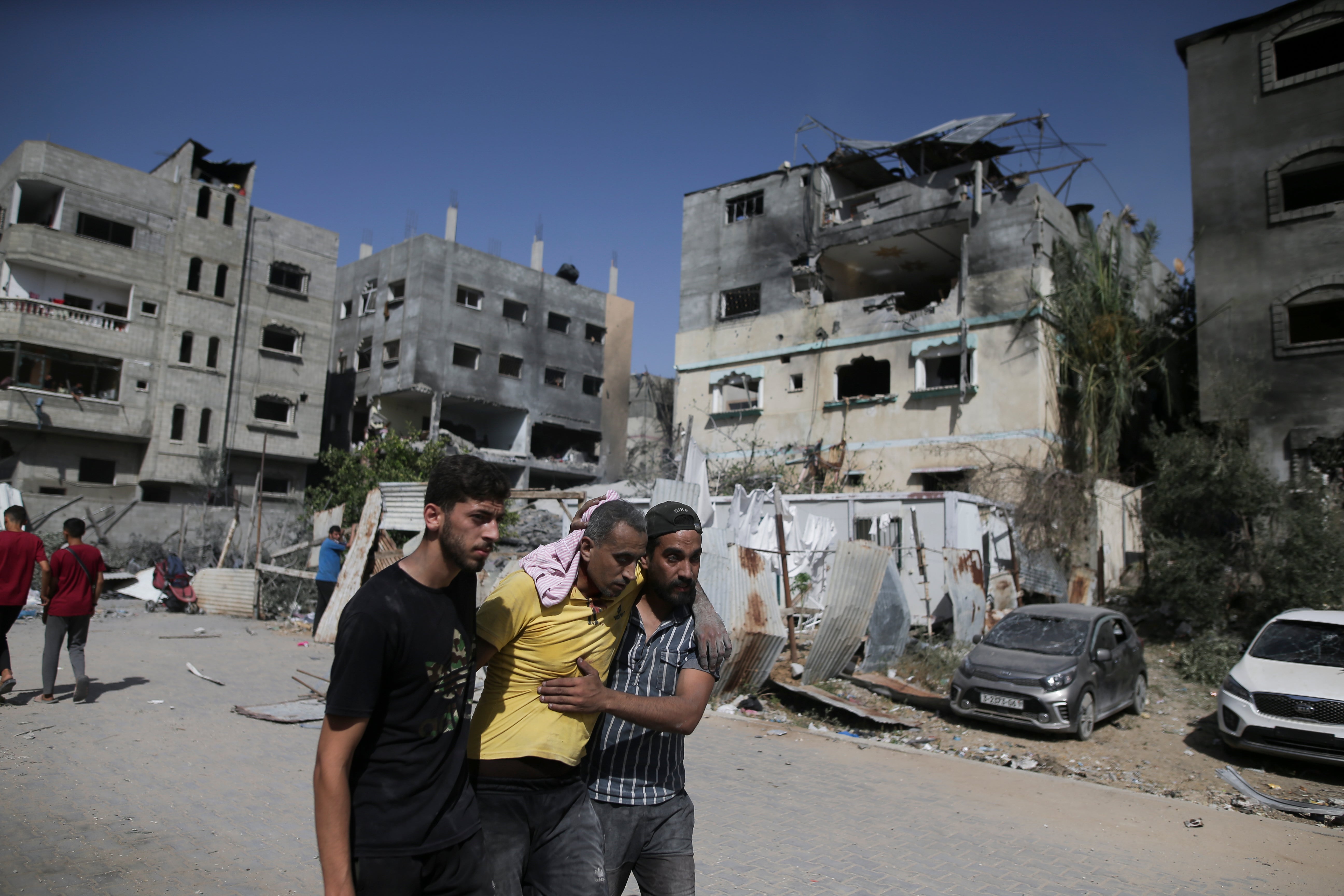 Palestinians help a wounded man after Israeli strikes in Nuseirat refugee camp