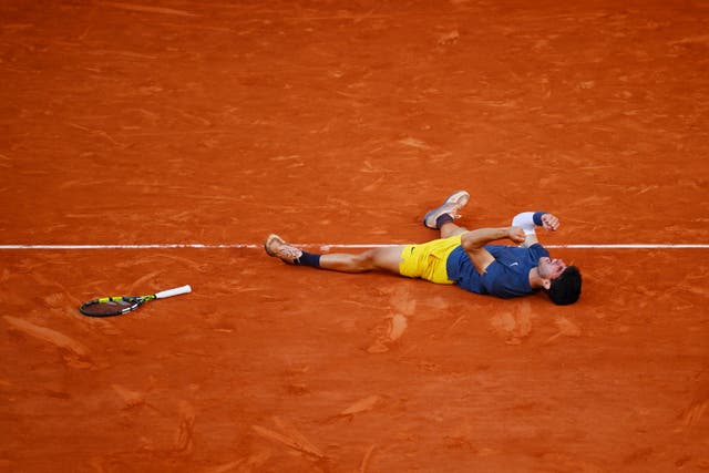 <p>Carlos Alcaraz falls to the clay after winning the French Open for the first time </p>