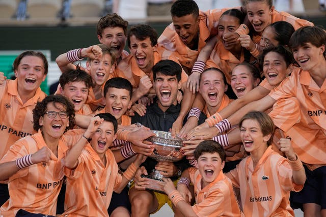 Champion Carlos Alcaraz poses with the ball kids (Thibault Camus/AP)