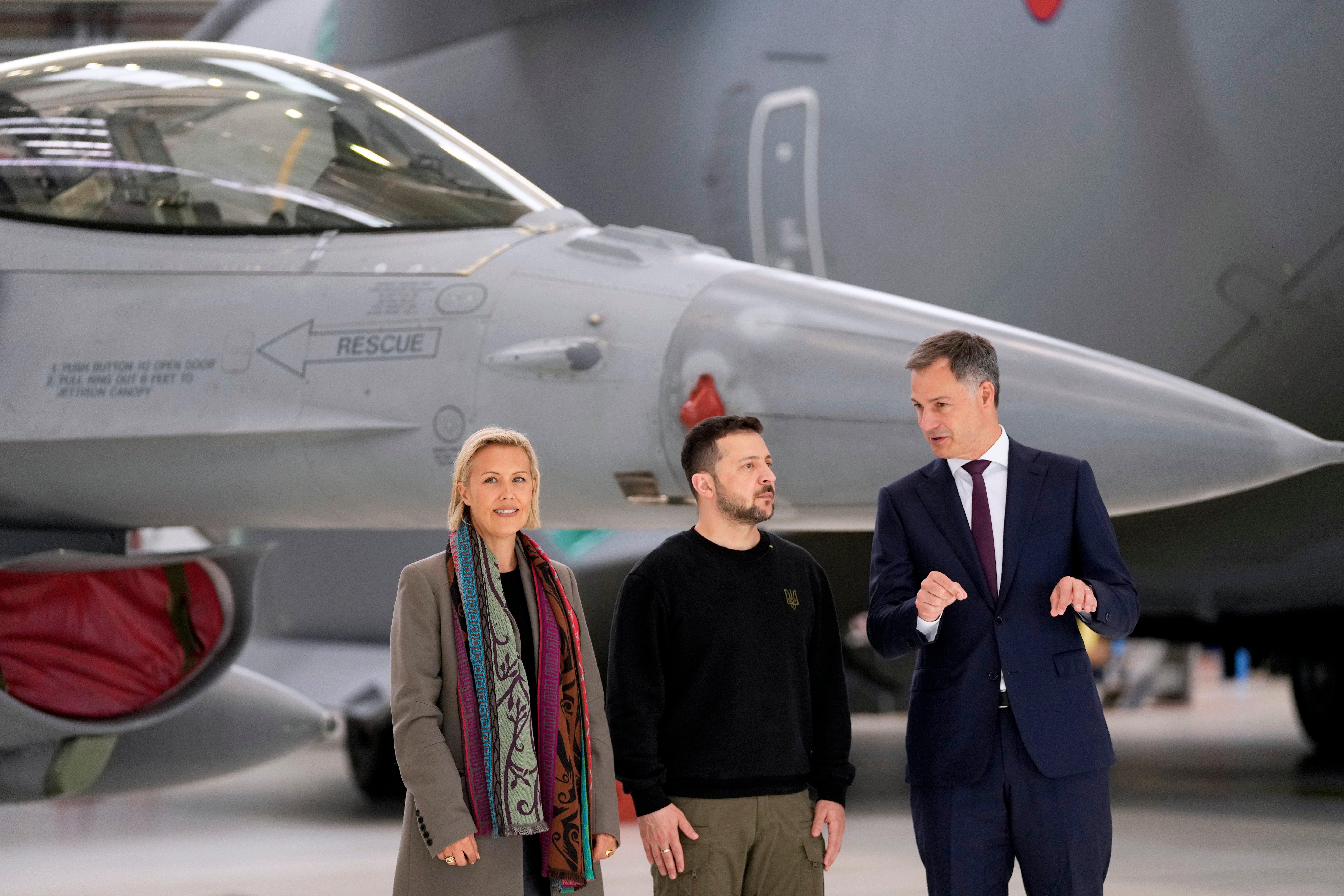 Belgium's Prime Minister Alexander De Croo, right, and Belgium's Defense Minister Ludivine Dedonder, left, pose with Ukraine's President Volodymyr Zelenskyy in front of an F-16