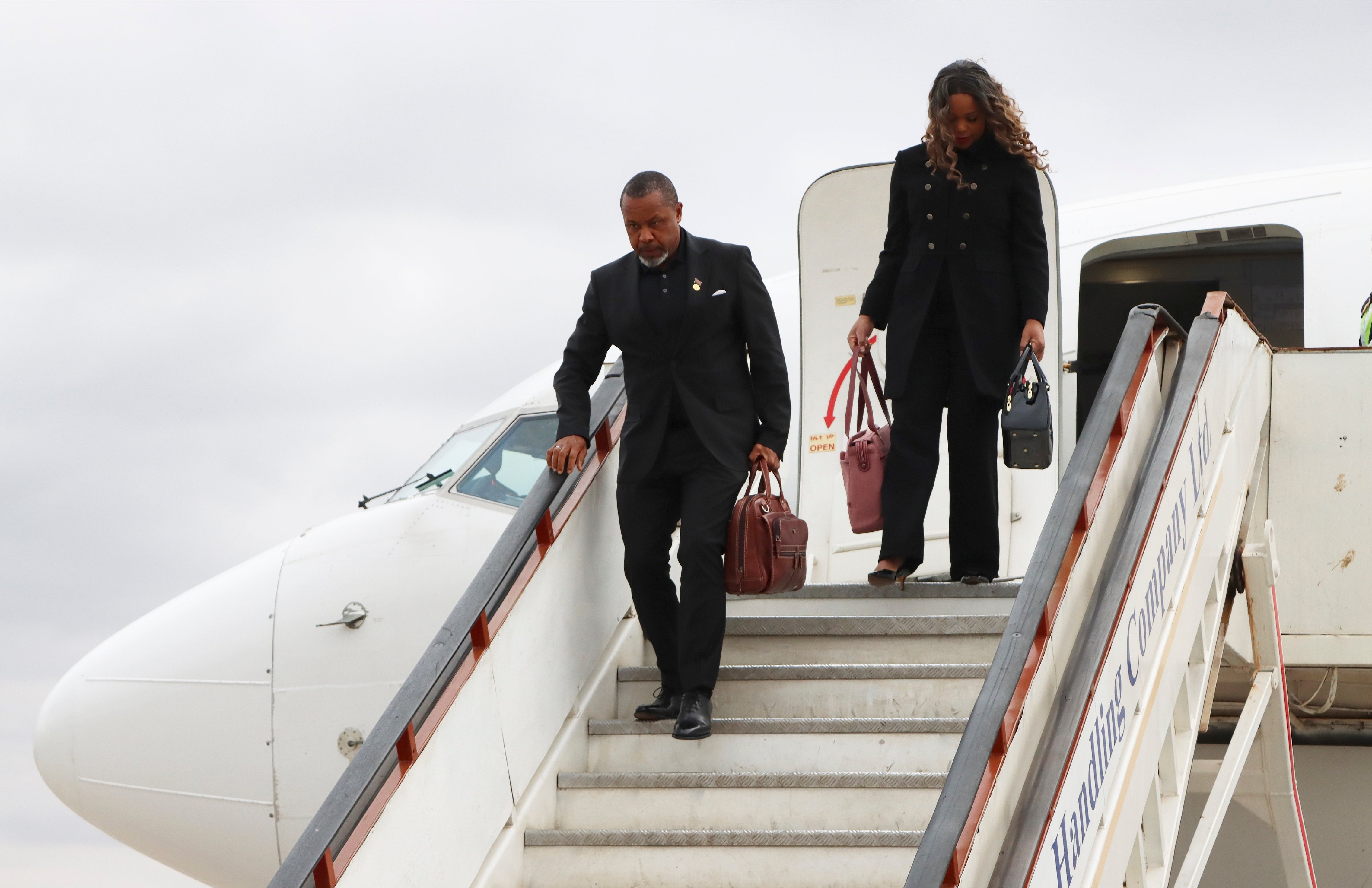Malawi vice-president Saulos Chilima, left, and his wife Mary disembark from a plane upon his return from South Korea