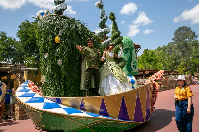 <p>Actors dressed as Princess Tiana and Prince Naveen from The Princess and the Frog perform on a float </p>