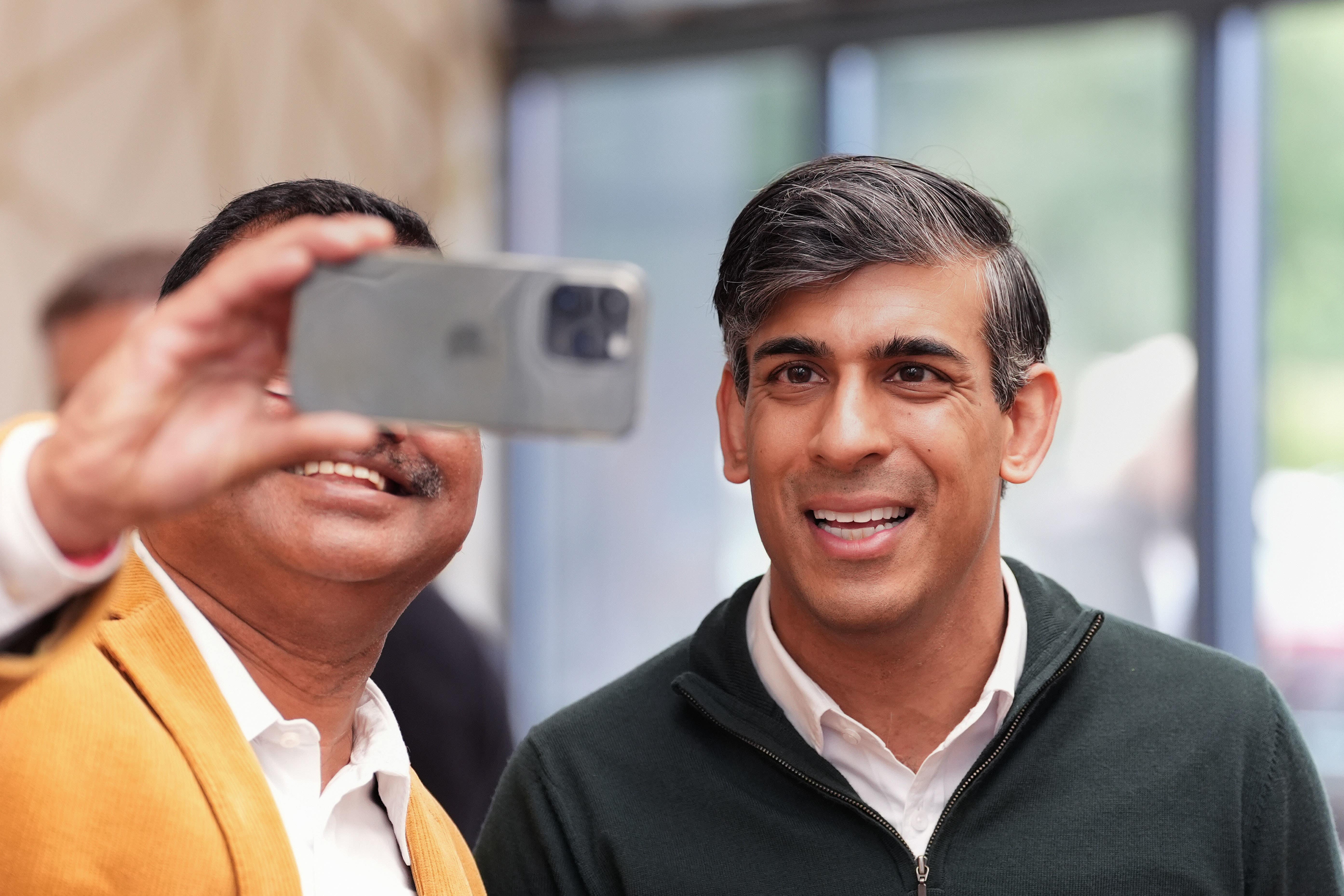 Prime Minister Rishi Sunak (right) has a selfie taken with a local at a cafe in Squires Garden Centre in Crawley, West Sussex, while on the General Election campaign trail (Gareth Fuller/PA)