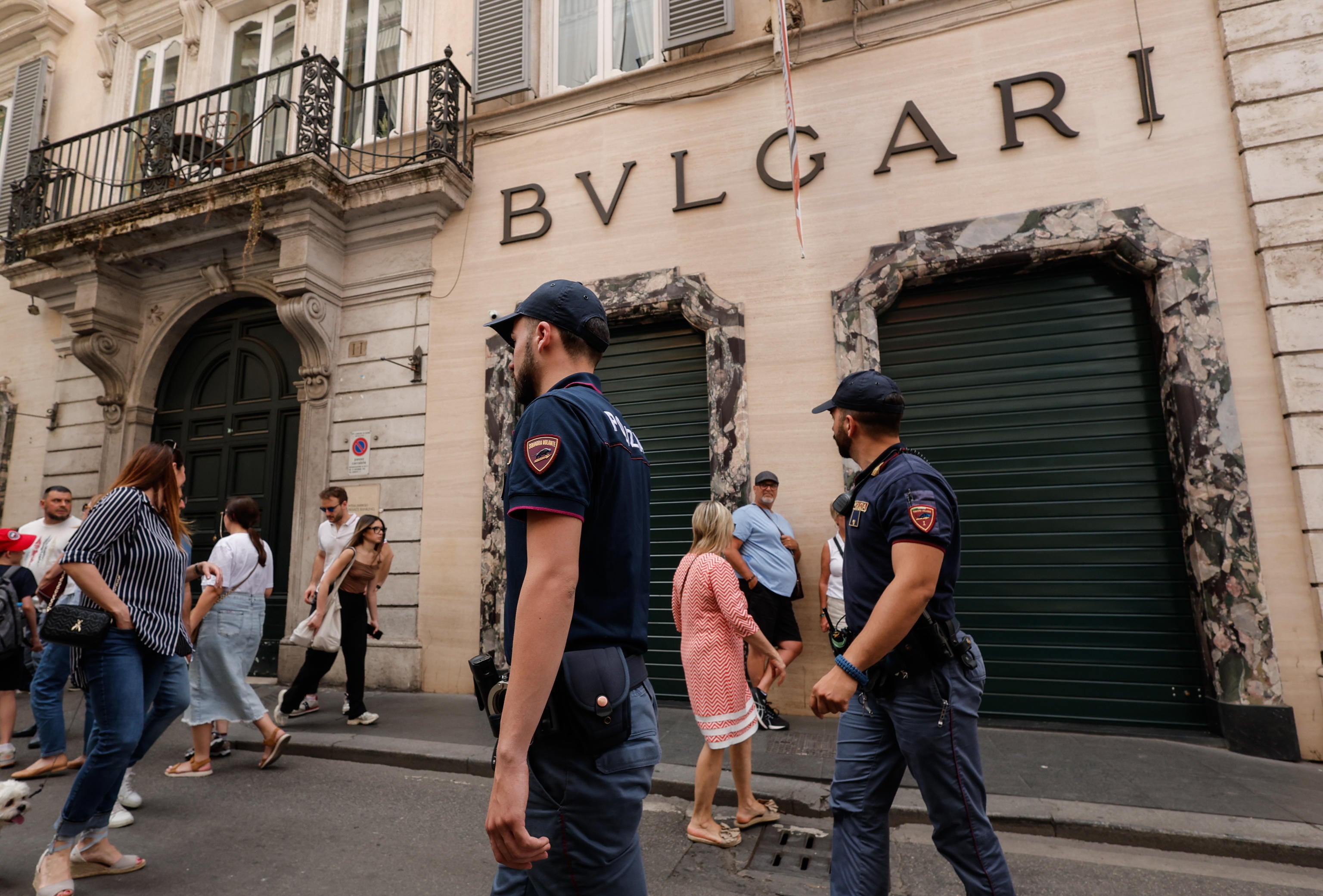 Police officers stand outside the Bulgari store in via Condotti, Rome