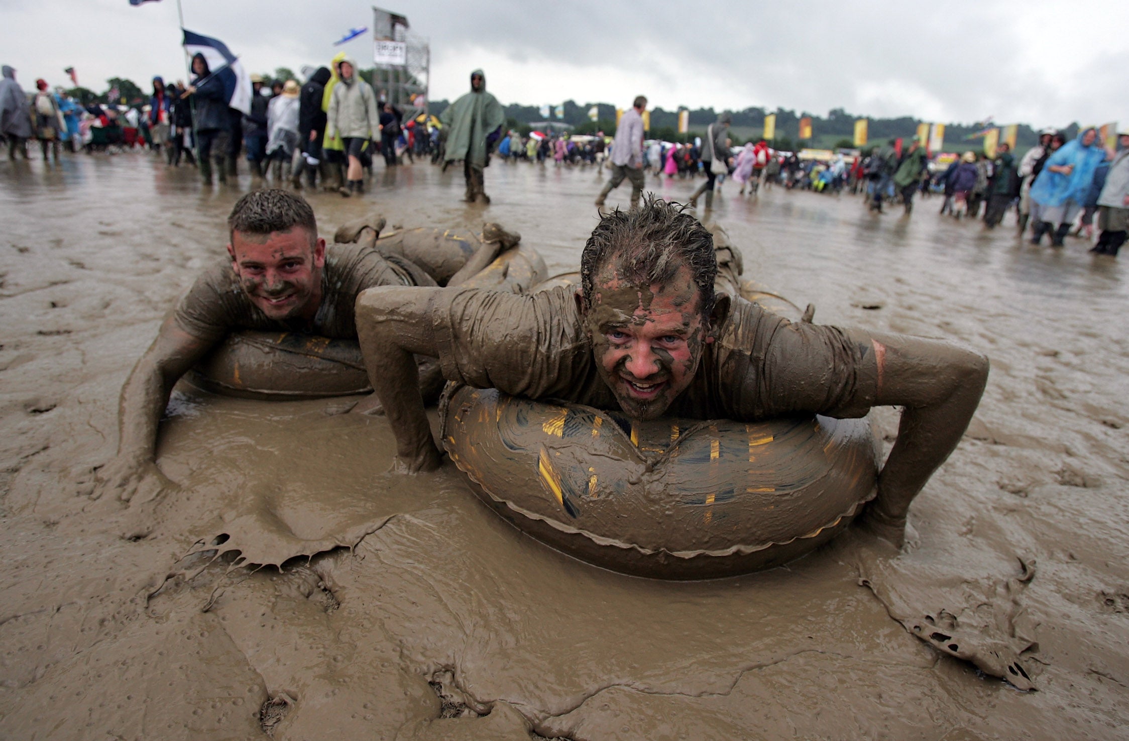 Two festival-goers sliding in the mud in 2007