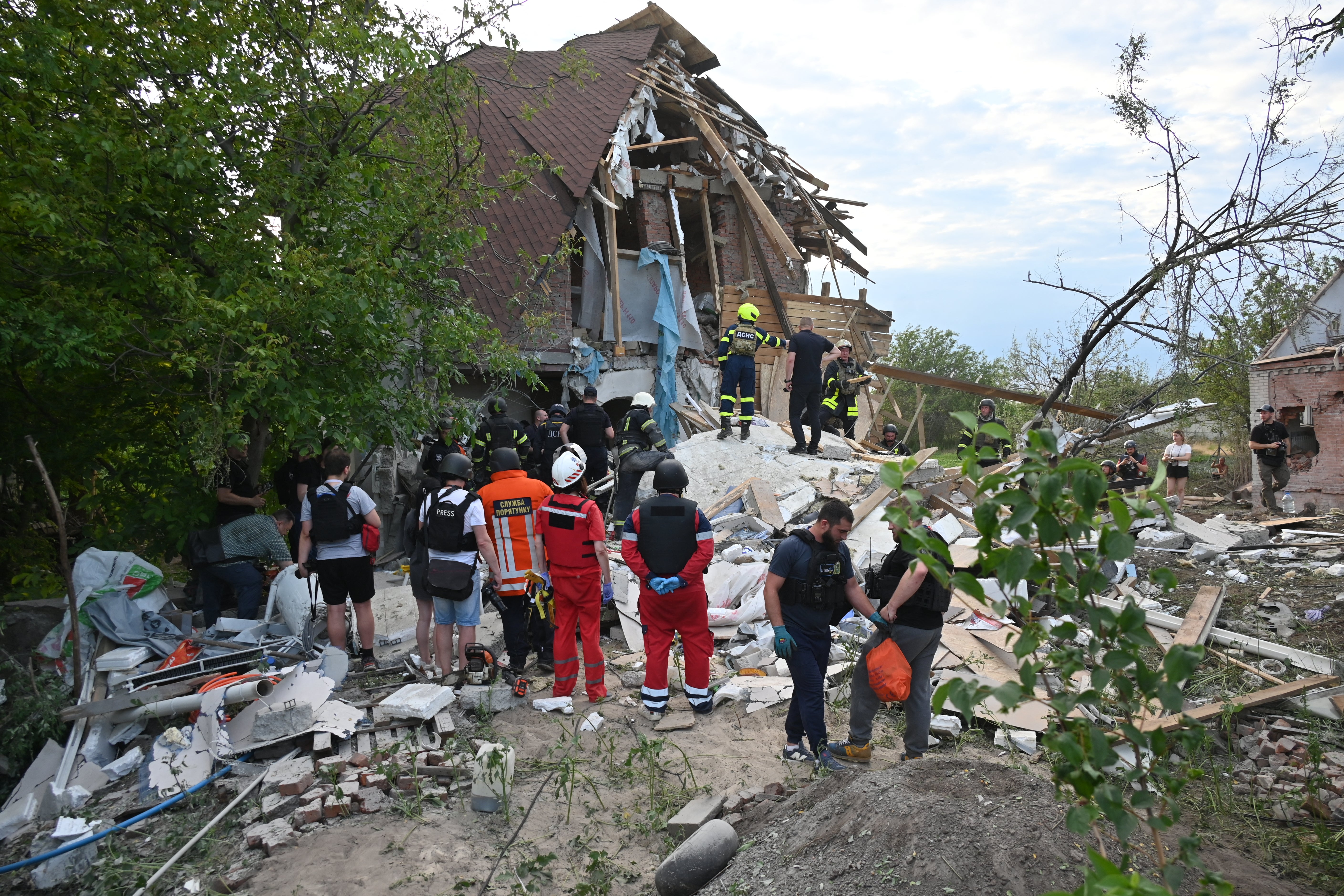 Rescuers work at the site of a house destroyed by an air strike, in Kharkiv