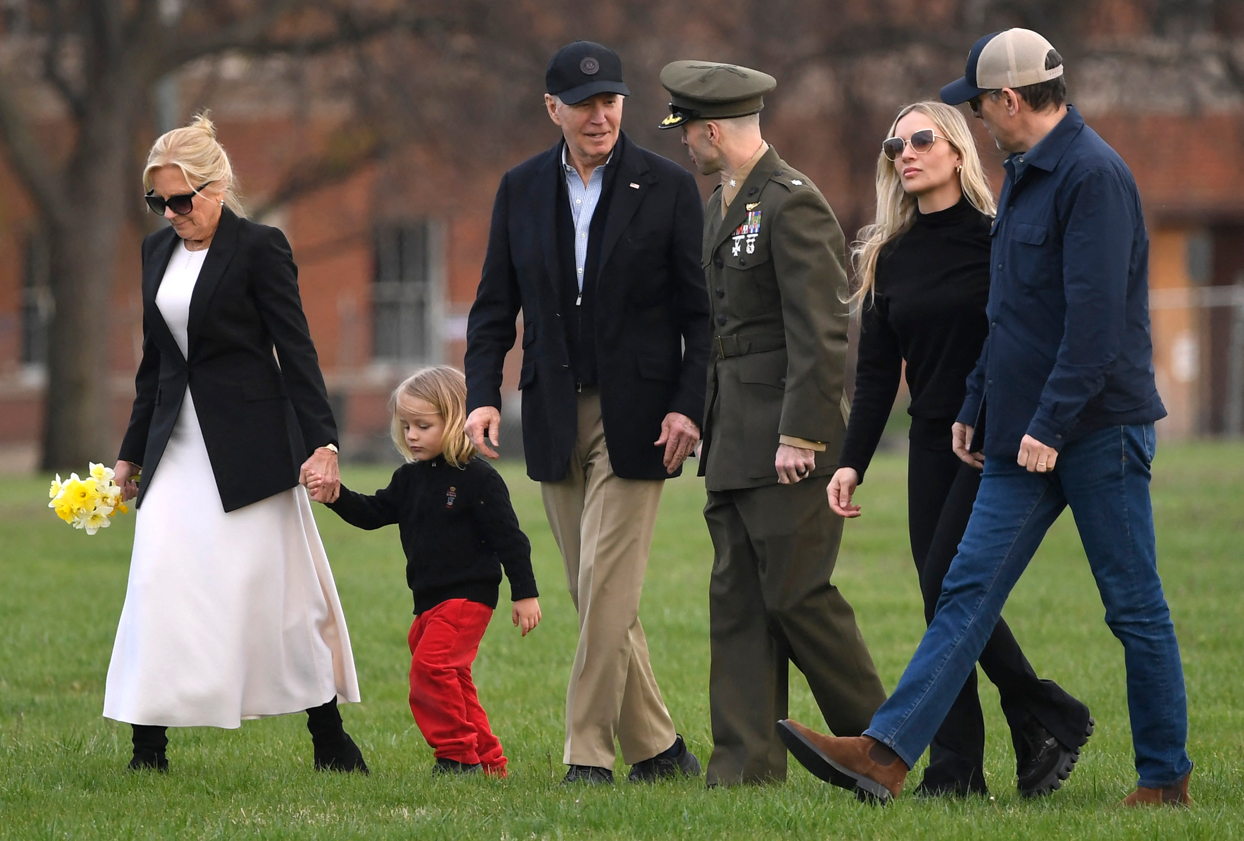 President Joe Biden talks to his Marine escort as he walks with grandson Beau and first lady Jill Biden as son Hunter Biden (R) walks with his wife Melissa, upon arrival at Fort McNair in Washington, DC, on March 31