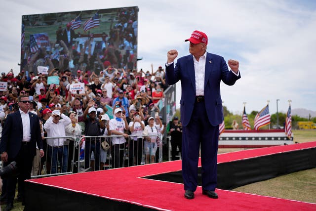 <p>Republican presidential candidate, former President Donald Trump motions as he walks on stage at a campaign rally on June 9, 2024</p>