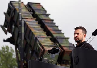 Ukraine's President Volodymyr Zelensky stands in front of a Patriot air defense missile system