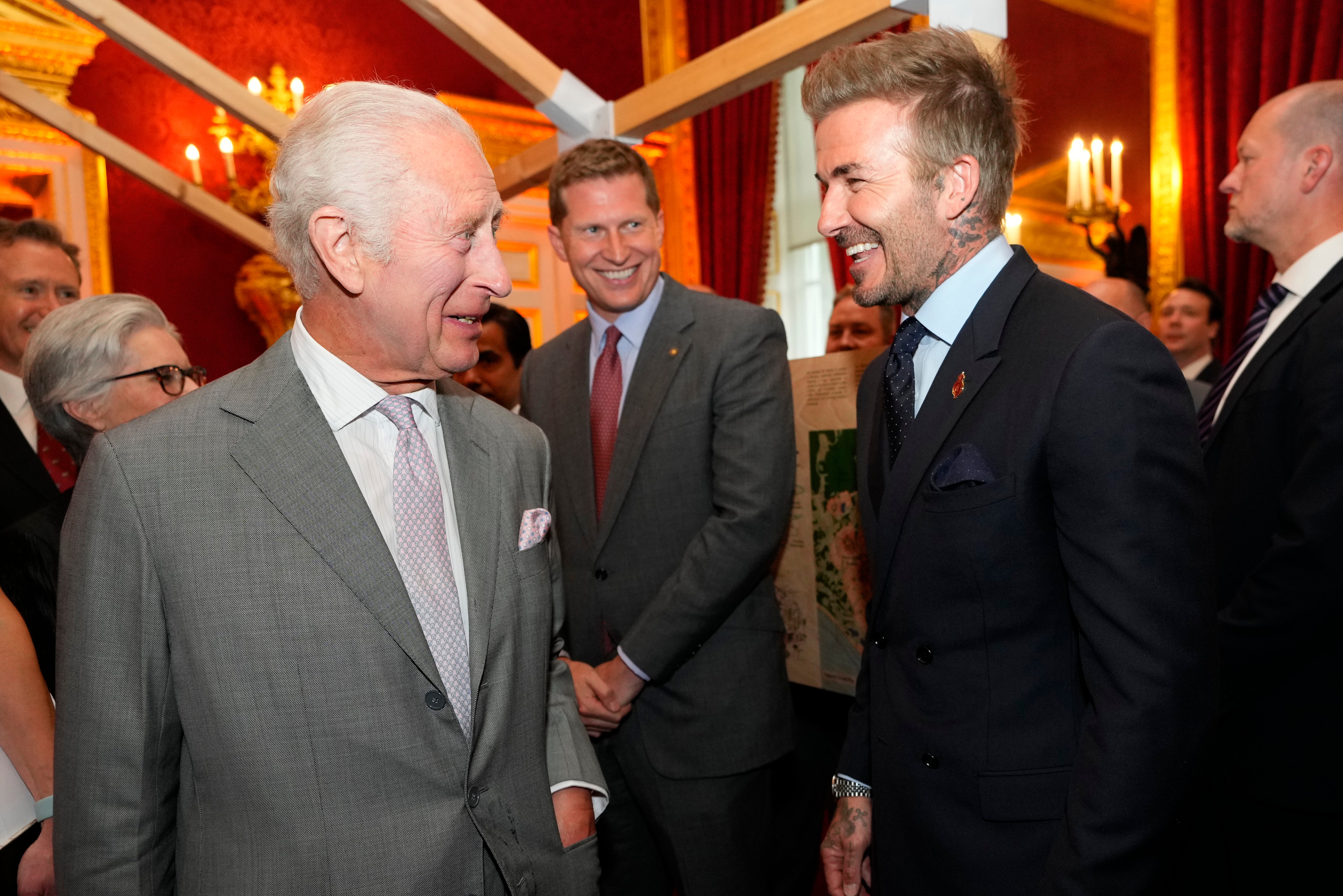 King Charles III laughs with former England footballer David Beckham