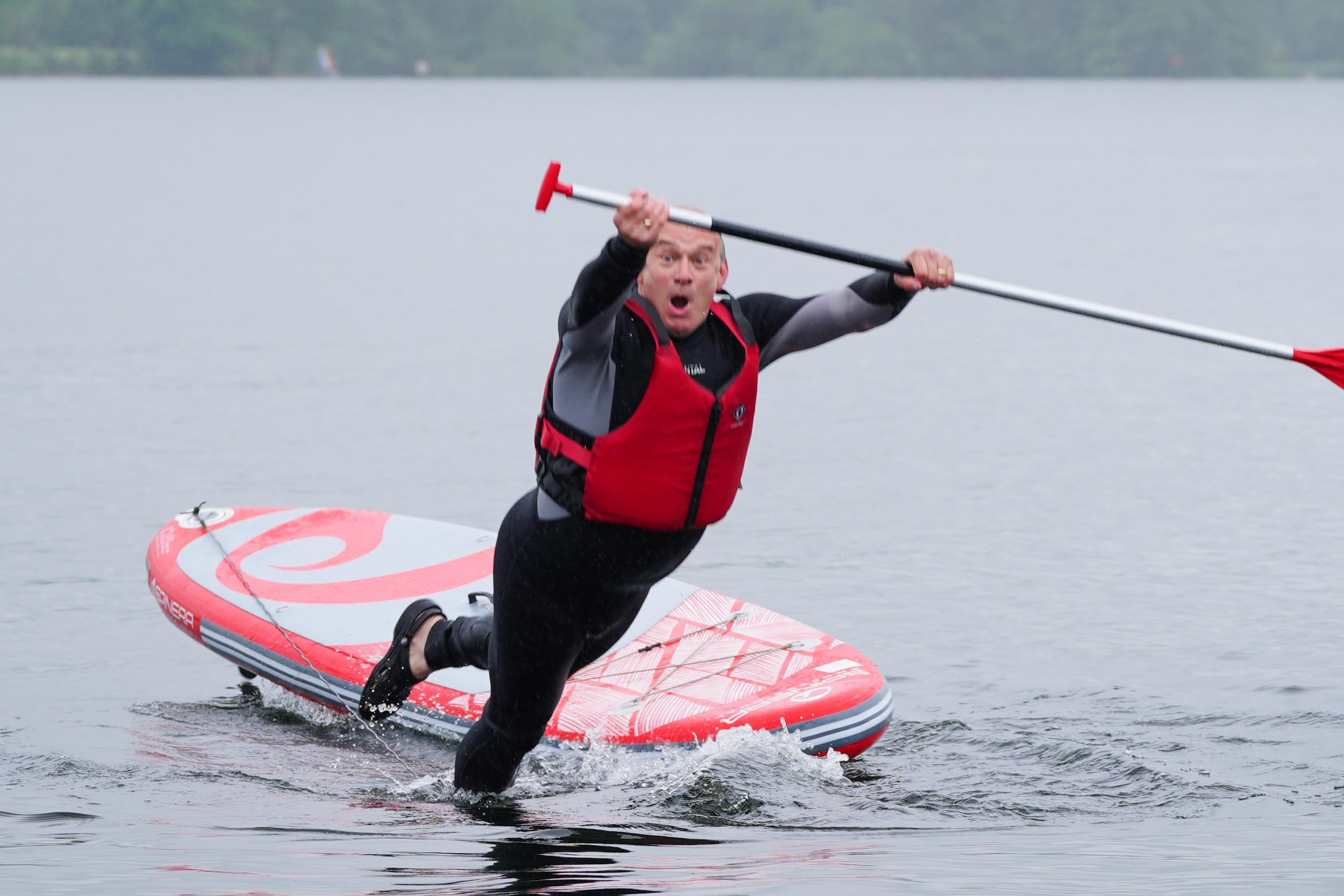 Liberal Democrat Leader Sir Ed Davey falls into the water while paddleboarding on Windermere, while on the General Election campaign trail (Peter Byrne/PA)