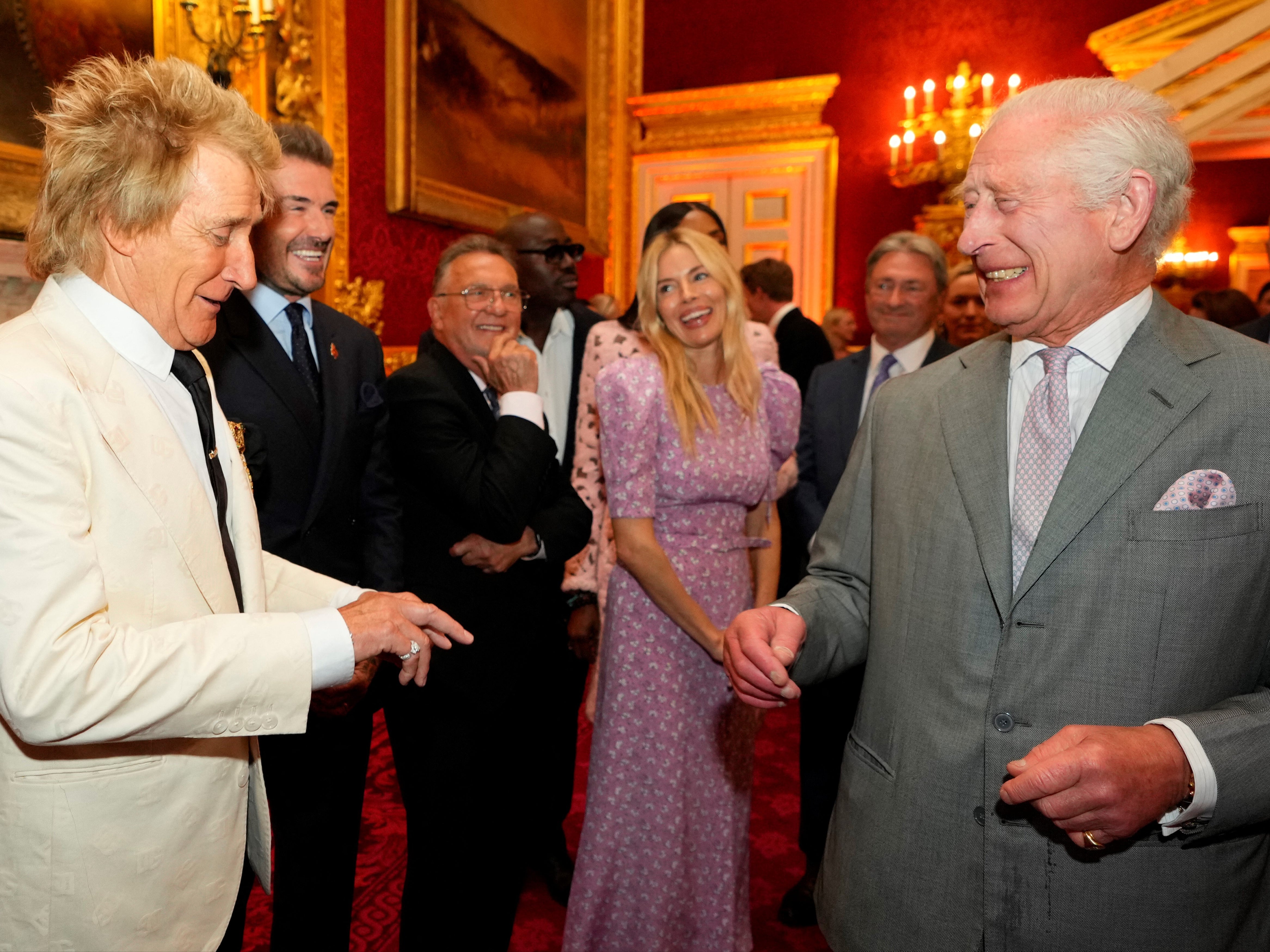 Король Чарльз сміється, розмовляючи з британським співаком Родом Стюартом, колишнім гравцем збірної Англії Девідом Бекхемом і британською актрисою Сієнною Міллер