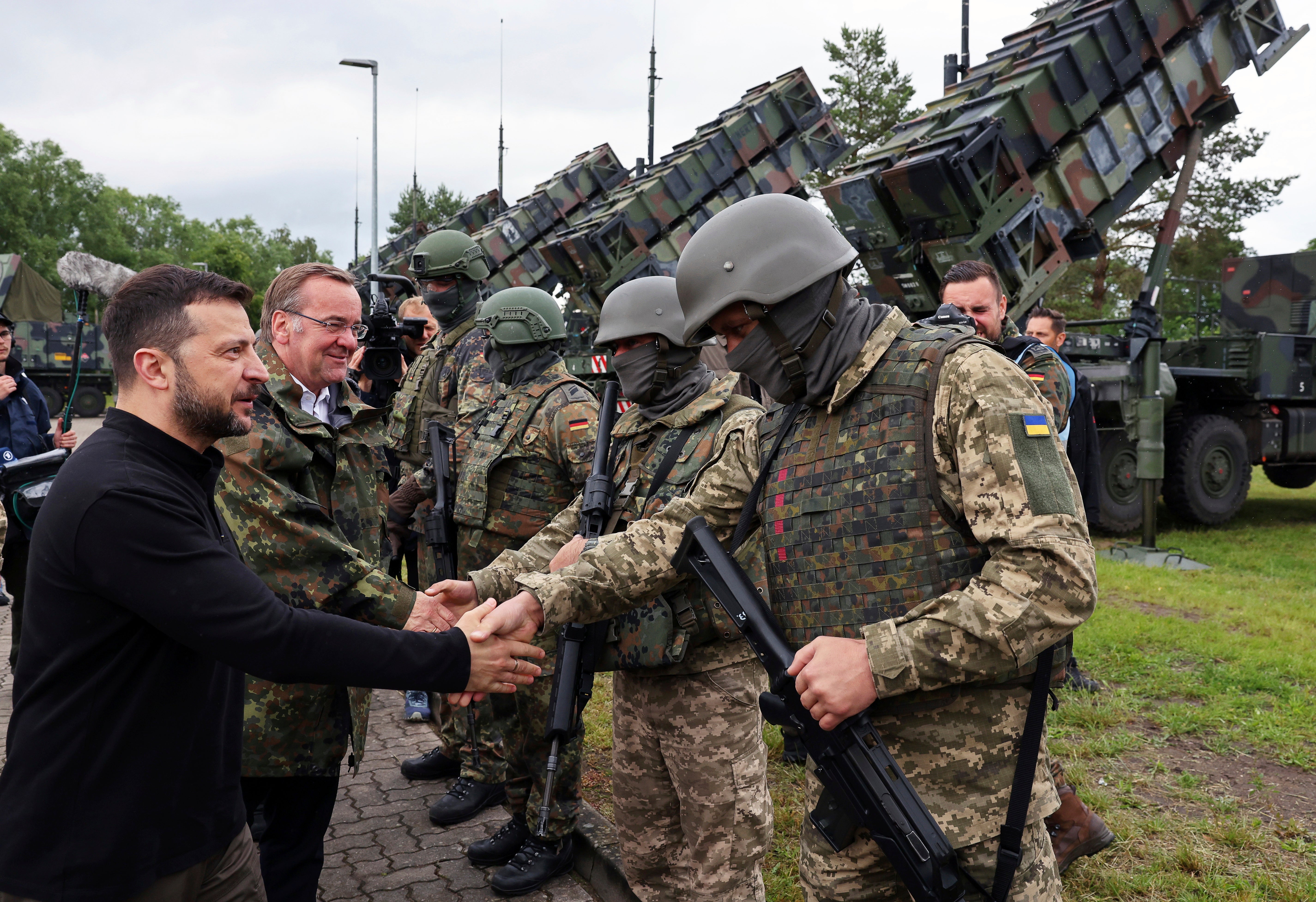 Volodymyr Zelenskyy, left, and German defence minister Boris Pistorius, second left, greet German and Ukrainian soldiers during their visit to a military training area to learn about the training of Ukrainian soldiers on the ‘Patriot’ air defence missile system (Jens Buettner/dpa via AP)