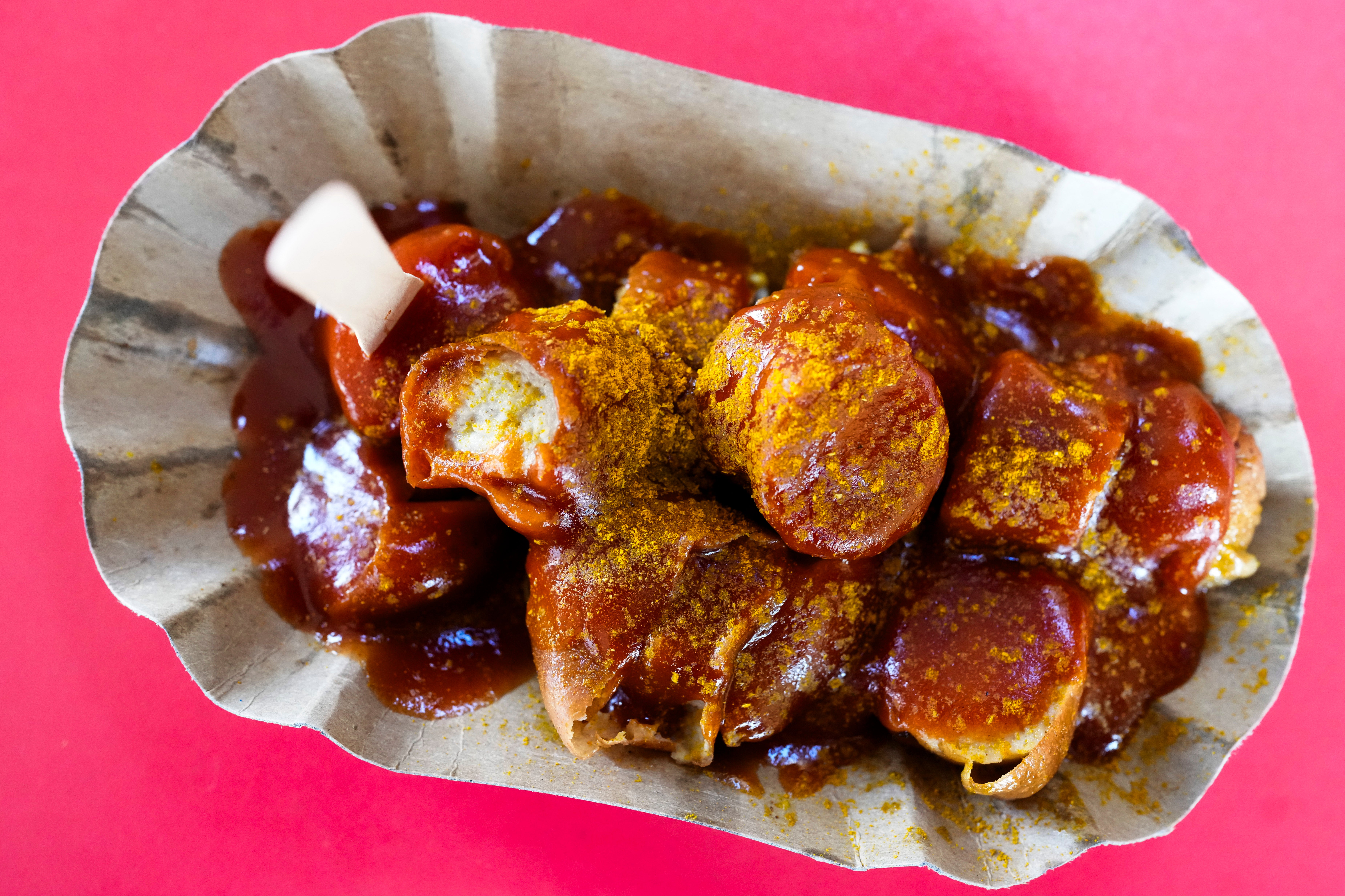 Currywurst, Germany’s sausage with curry sauce, served on a cardboard at Konnopke’s Imbiß