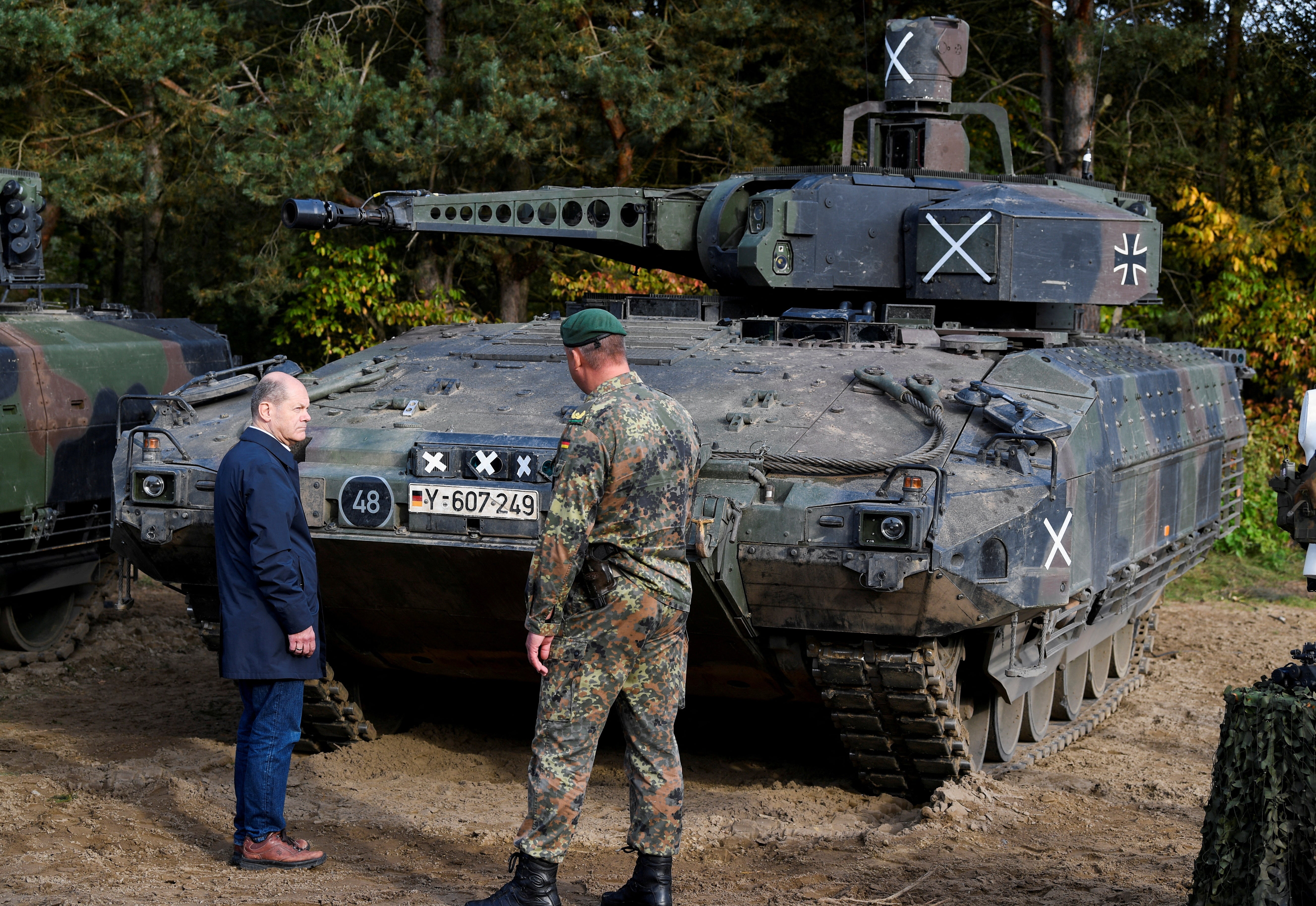 German Chancellor Olaf Scholz stands in front of a Puma vehicle during a visit to a military base of the German army Bundeswehr in Bergen, Germany, October 17, 2022