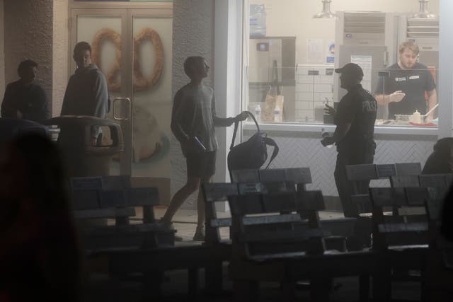 <p>A young man shows his backpack to a police officer in Ocean City, N.J., on Memorial Day weekend. Wildwood, New Jersey, is expected to pass a backpack ban to combat teen disturbances at the boardwalk </p>