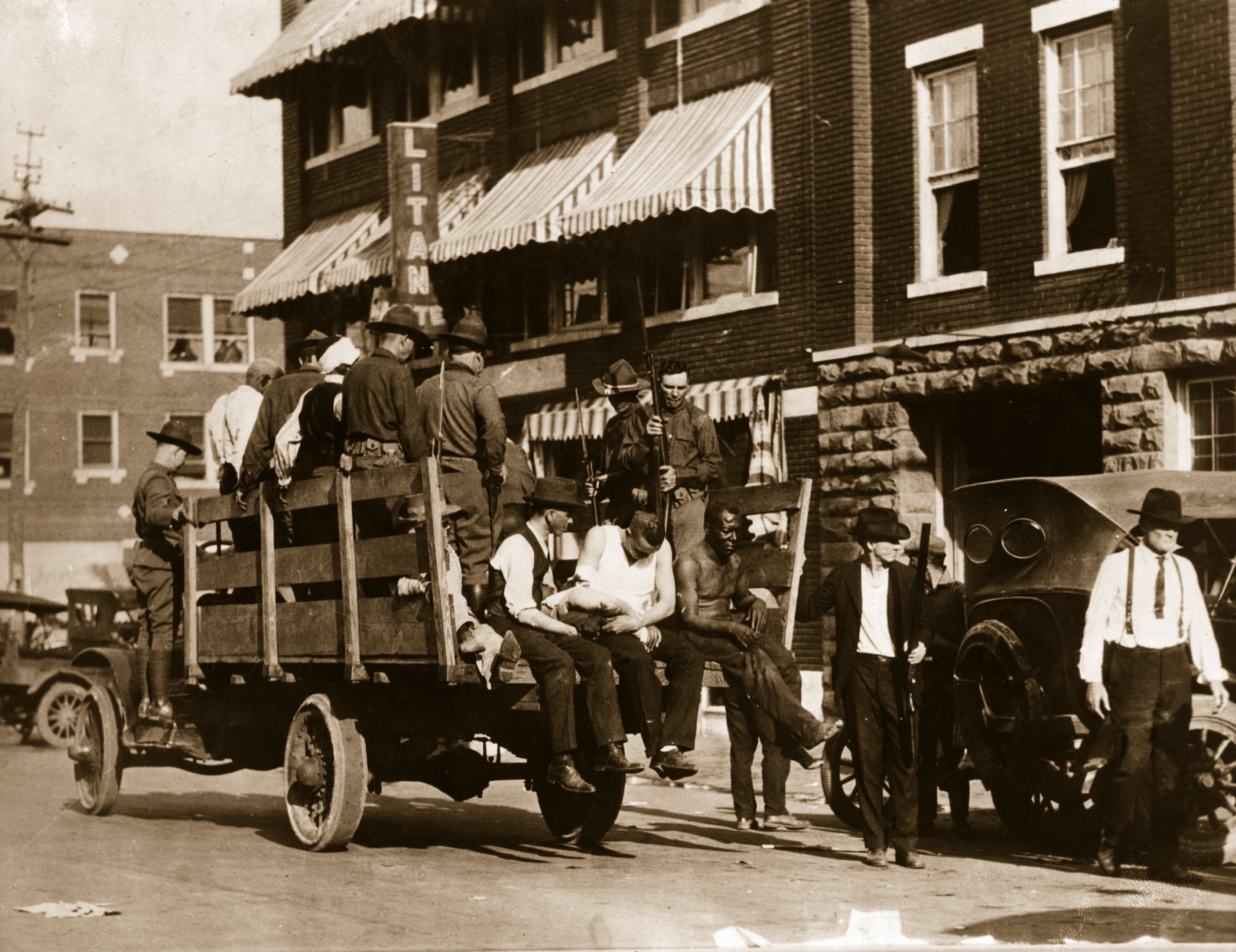 National guardsmen carry injured and wounded men in the aftermath of the Tulsa race massacre in 2021.