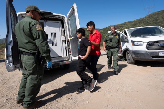 <p>US border patrol agents lead a group of migrants seeking asylum towards a van to be transported and processed near Dulzura, California on June 5. Civil rights groups sued the Biden administration on June 12 to block an executive order that significantly limits asylum claims.</p>