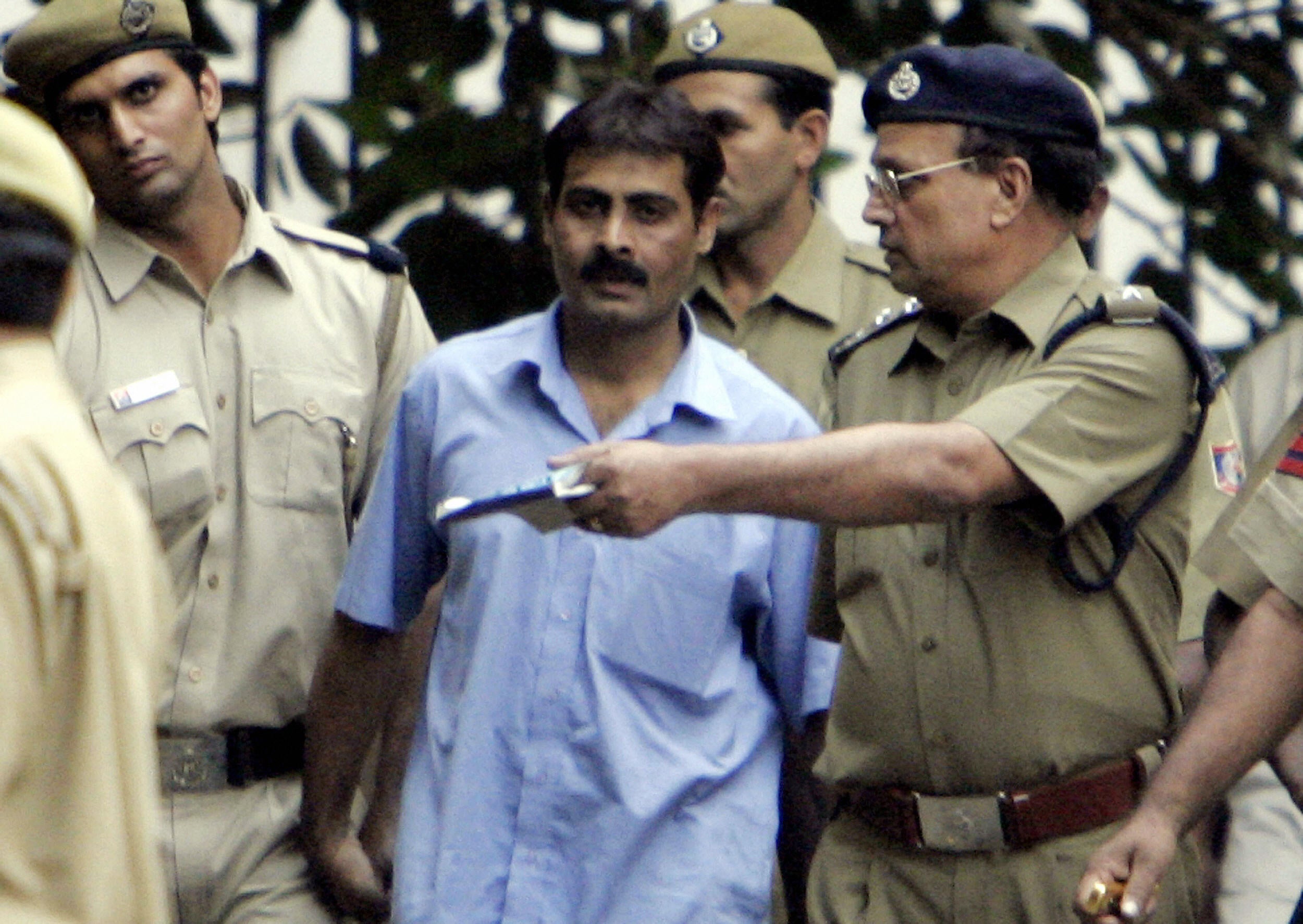 Pakistani man Mohammad Arif (C) is escorted by Indian policemen as he walks out of the Karkardooma court in New Delhi in 2005