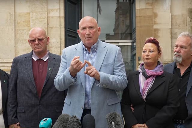 <p>Dunn family spokesperson Radd Seiger (centre) with Harry’s relatives </p>