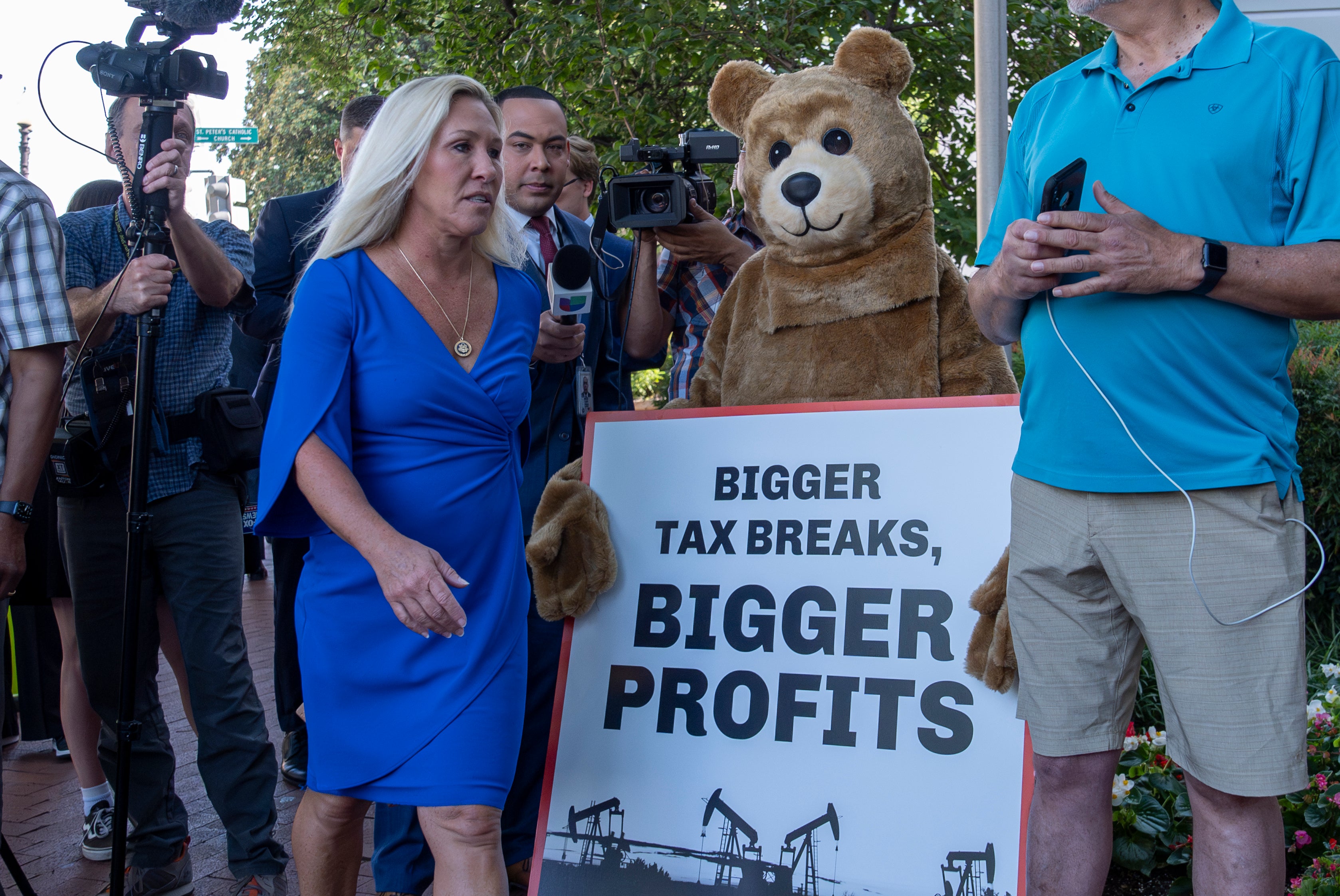 Marjorie Taylor Greene walks past a protester in a bear costume before a meeting with Donald Trump at the Capitol Hill Club on June 13.