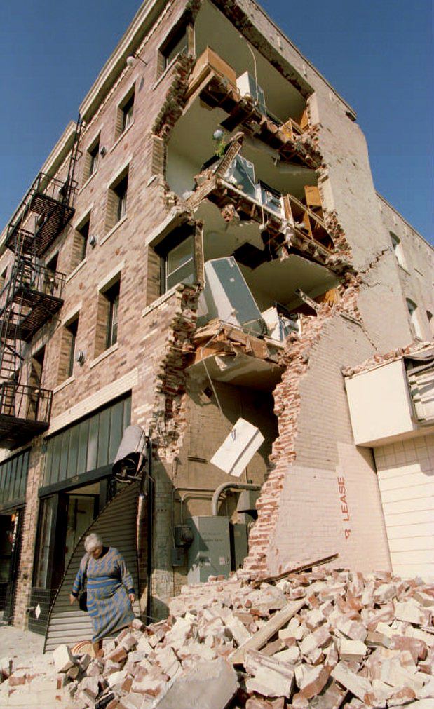 Aykui Alaverdyan walks over rubble after taking some of her belongings from her Hollywood Boulevard apartment building in Hollywood, CA, 20 January 1994, which was destroyed in the Northridge earthquake