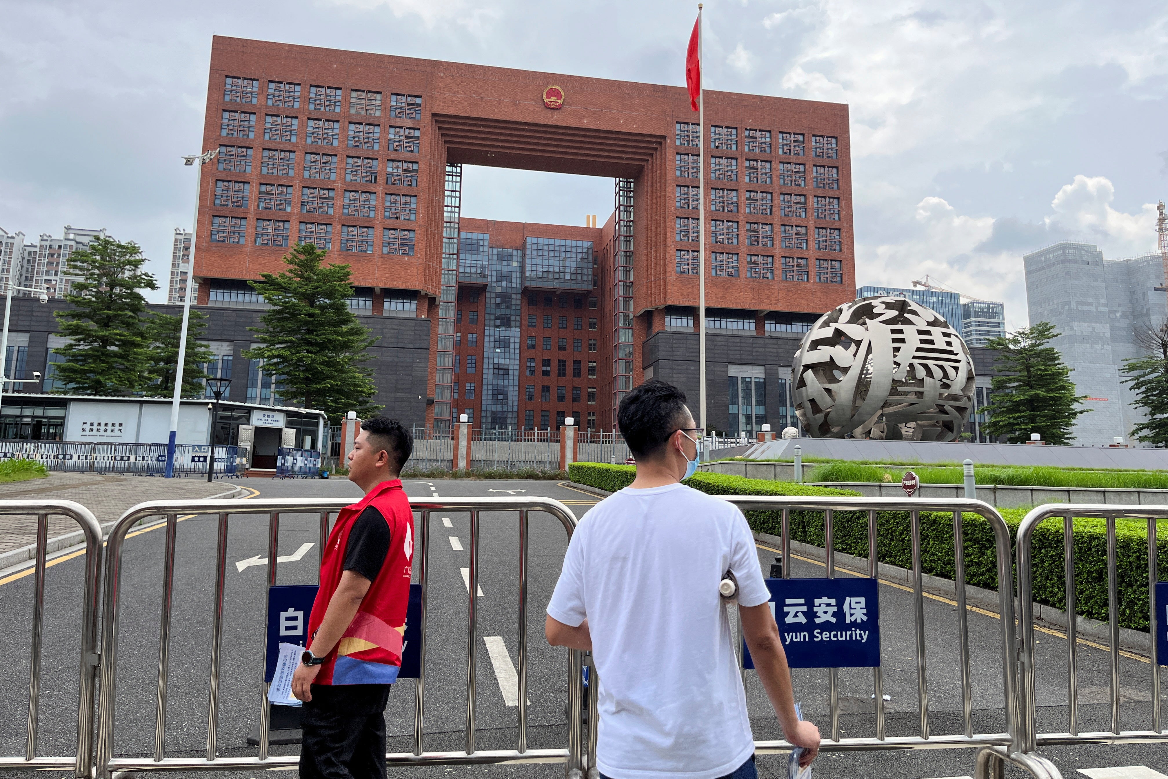 People stand outside Guangzhou Intermediate People's Court