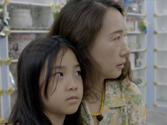 <p>Jang Ji-Sung, pictured with one of her children, has been using AI to get closure after her daughter’s death </p>