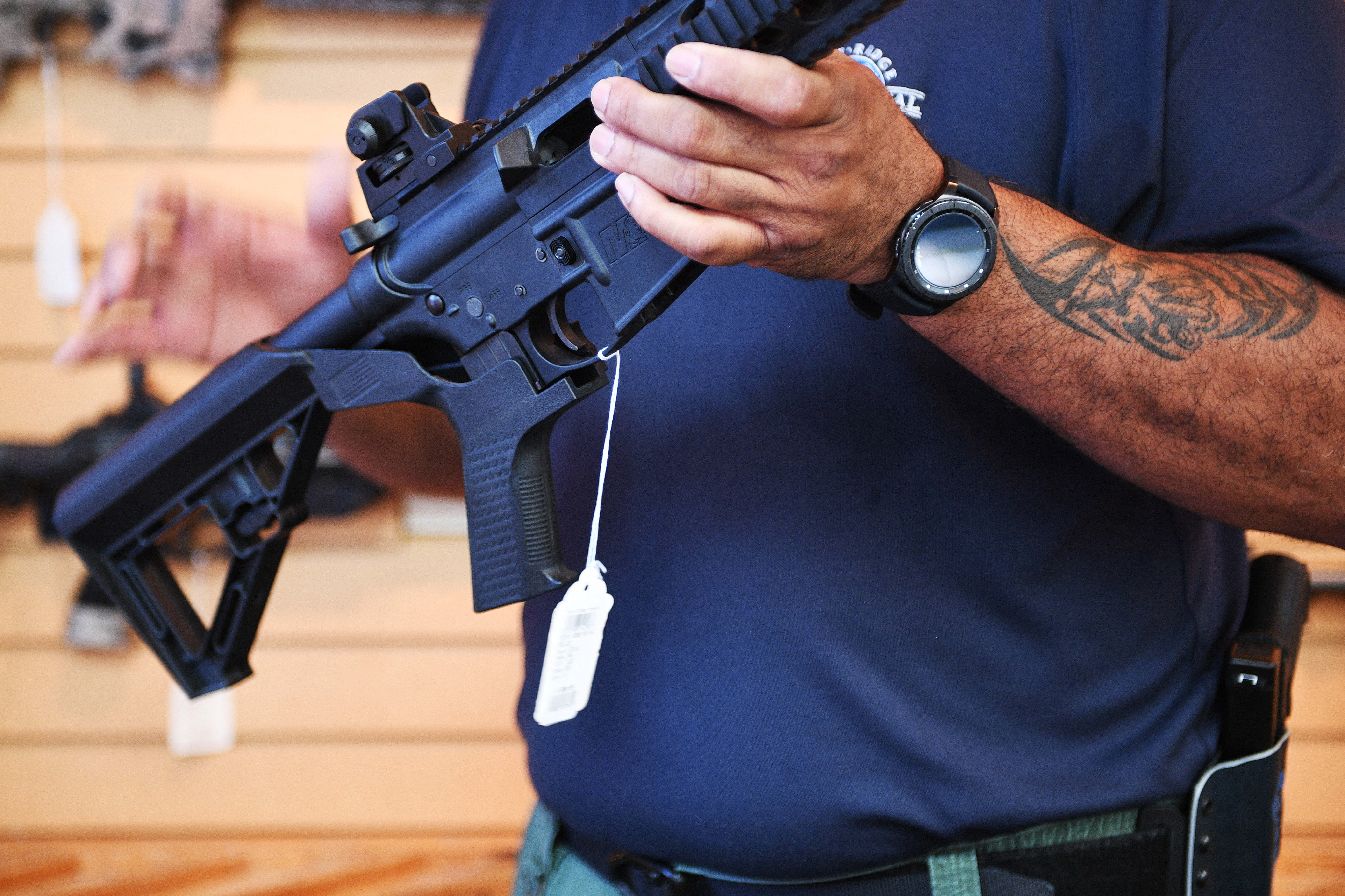 A gun salesman demonstrates a bump stock on an AR-style rifle in Virgina. On June 14, the US Supreme Court reversed a federal ban on the devices.