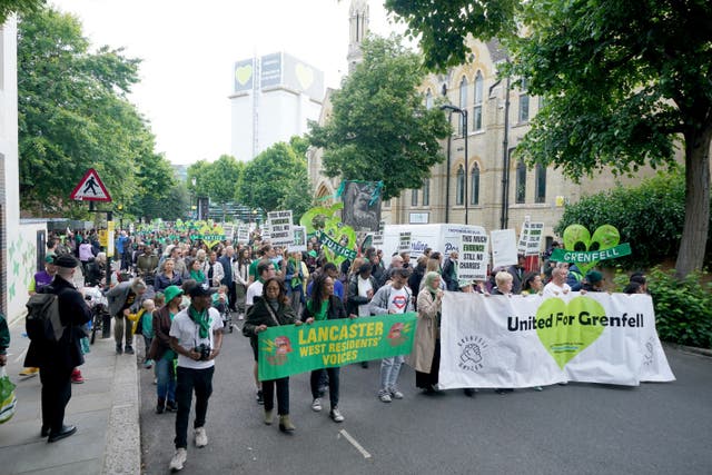 People take part in a silent walk near Grenfell Tower in London, in remembrance of those who died in the Grenfell Tower fire on June 14 2017 (Yui Mok/PA)