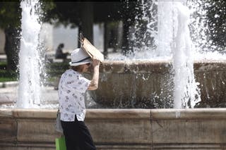 Μια γυναίκα προστατεύεται από τον ήλιο περπατώντας στην Ελλάδα