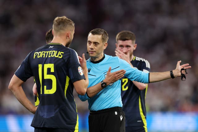 <p>Referee Clement Turpin shows a red card to Ryan Porteous</p>
