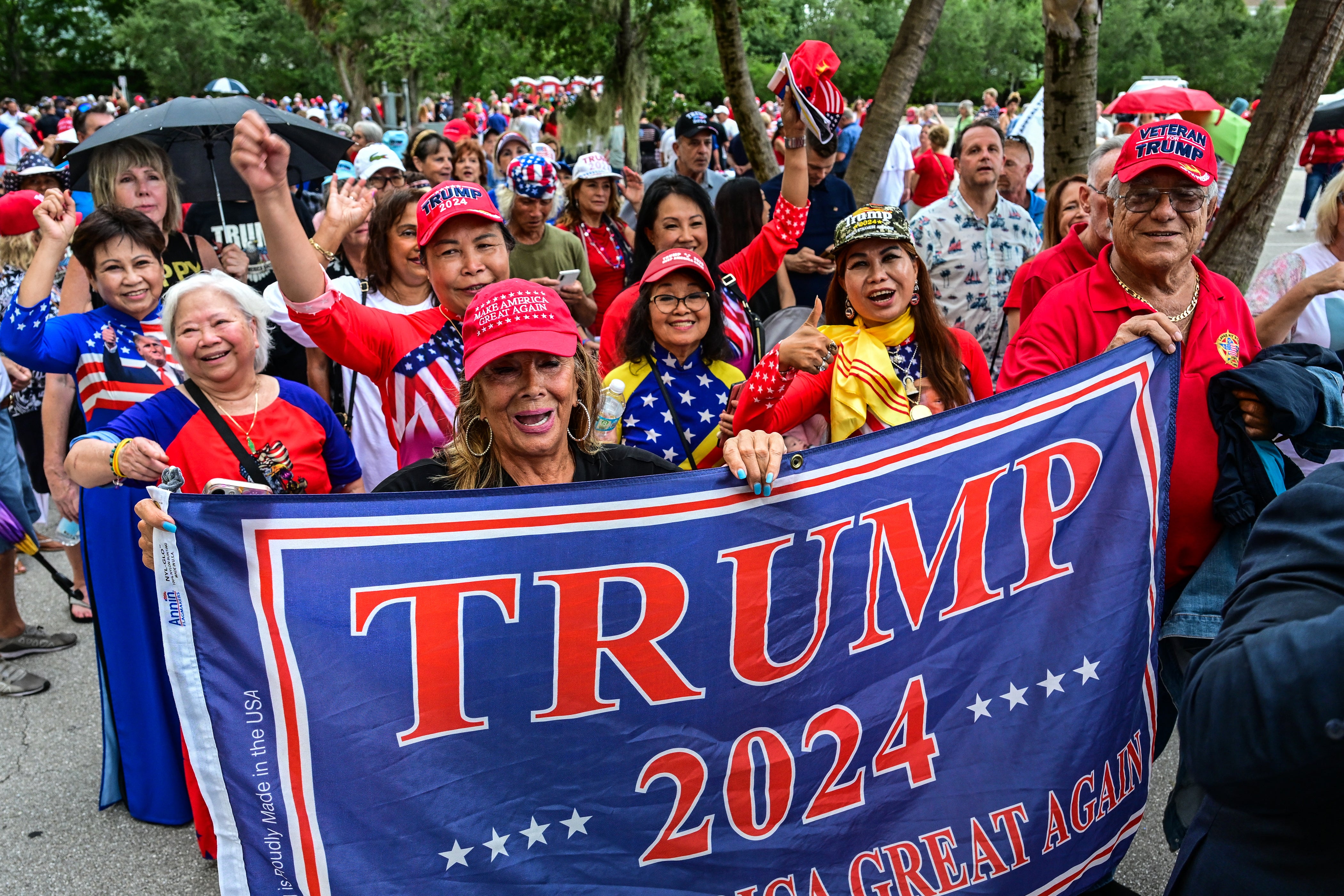 Supporters of former US President and Republican presidential candidate Donald Trump wait to enter the West Palm Convention Center for a campaign rally as he celebrates his 78th birthday