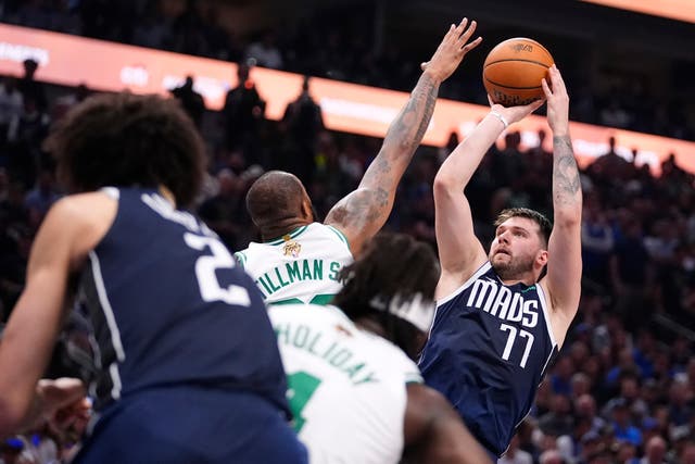 Dallas Mavericks guard Luka Doncic (77) shoots over Boston Celtics forward Xavier Tillman (Julio Cortez/AP)