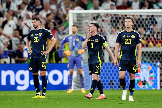 <p>Scott McKenna, Andy Robertson and Kenny McLean appear dejected after Emre Can scores</p>